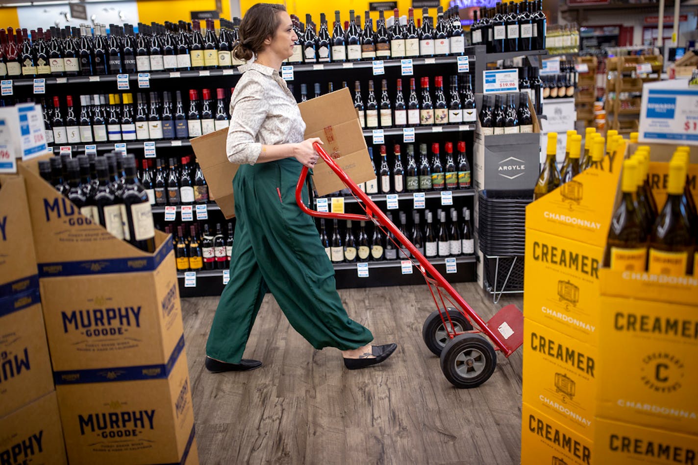 Aimee Hutchinson, the wine manager and content writer for Top Ten Liquors, stocked wine at the Roseville location, Monday, May 24, 2021. The Twin Cities-based chain just raised its minimum wage to $15. It's one of a number of employers who have ben raising wages to attract and retain workers. ] ELIZABETH FLORES • liz.flores@startribune.com ORG XMIT: MIN2105241302311397