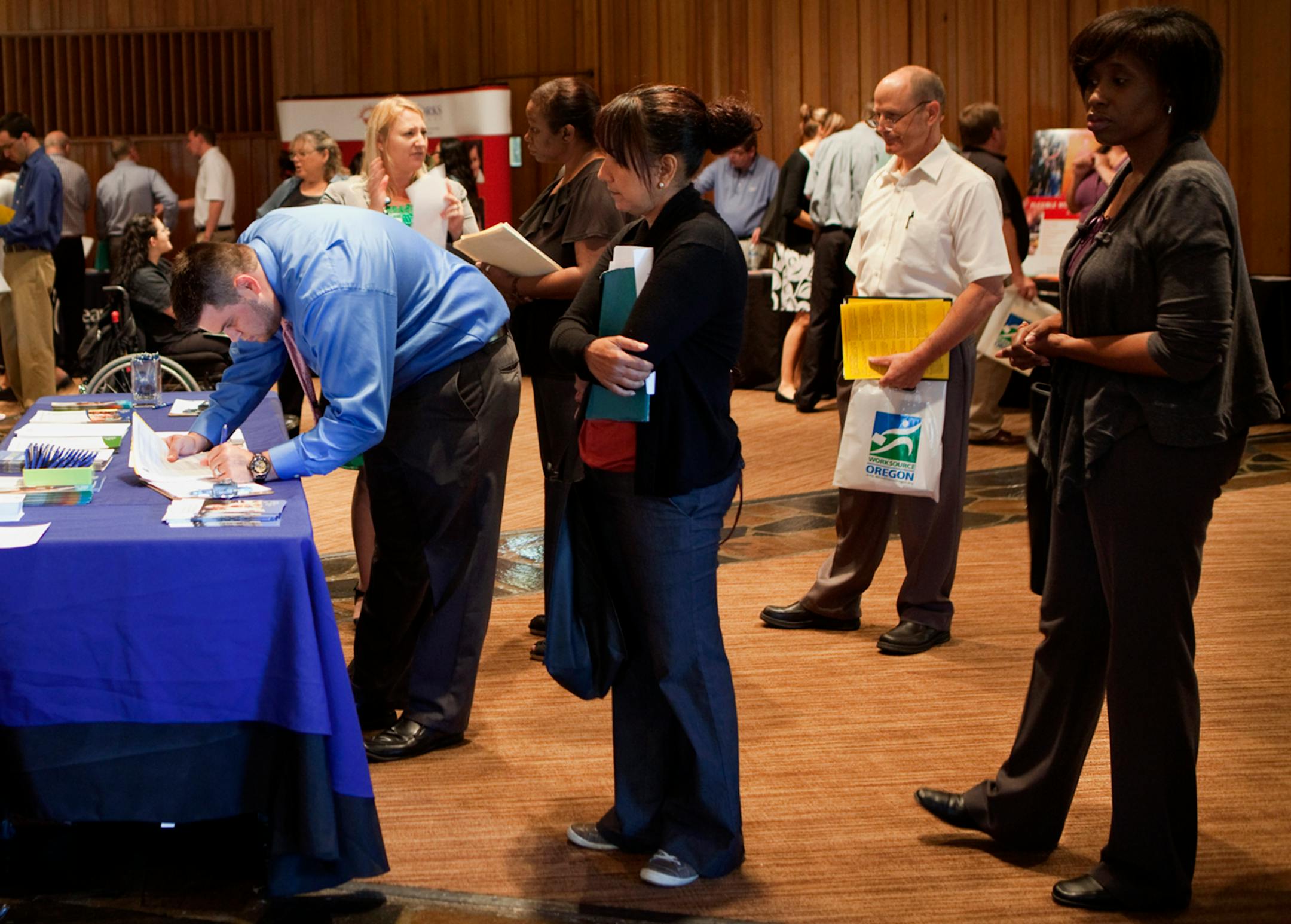 Job seekers line up to meet potential employers at the annual Maximum Connections job fair in Portland, Oregon, U.S., on Thursday, Sept. 12, 2013. Jobless claims in the U.S. declined last week to the lowest level since April 2006 as work on computer systems in two states caused those employment agencies to report fewer applications. Photographer: Natalie Behring/Bloomberg