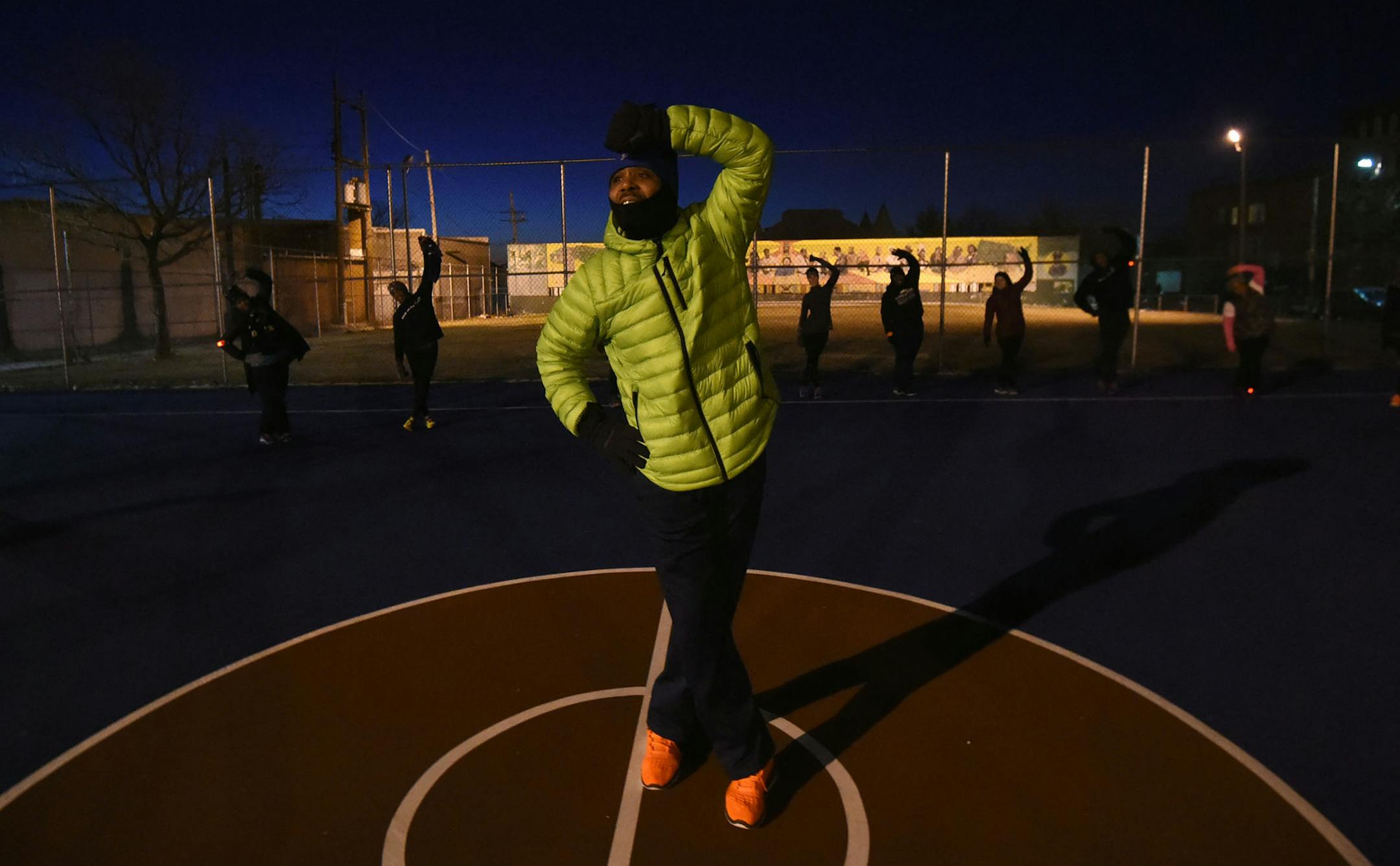 Pearly Blue, W Baltimore, leads Penn North Housing residents and volunteers in stretching on a basketball court on N Carey St. after their pre-dawn Back on My Feet (BOMF) run/walk on Friday morning. BOMF uses running to change the lives of people struggling with homelessness. Blue is a 2012 alumnus of the group. (Kim Hairston/Baltimore Sun/TNS)