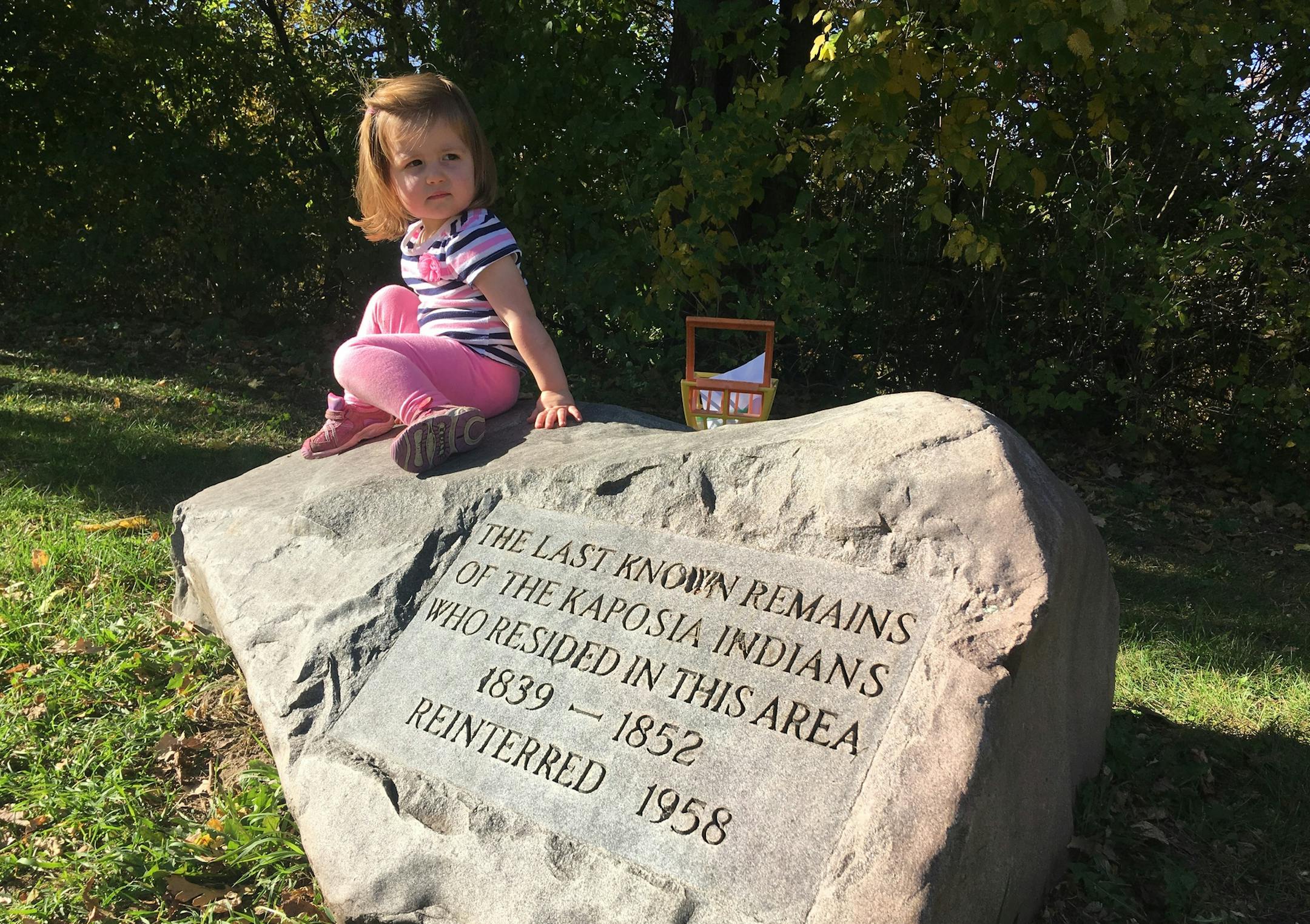 Hadley Kull, 2, climbs on the stone commemorating the site where Kaposia Indian remains were reburied in 1938 and again in 1958.