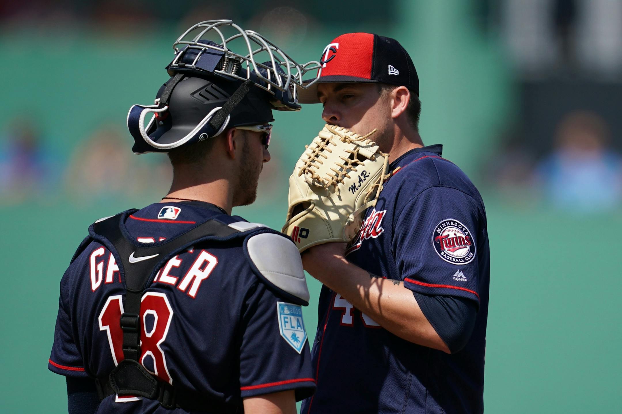 Minnesota Twins catcher Mitch Garver (18) talked with Minnesota Twins relief pitcher Addison Reed (43) on the mound during Sunday's game.