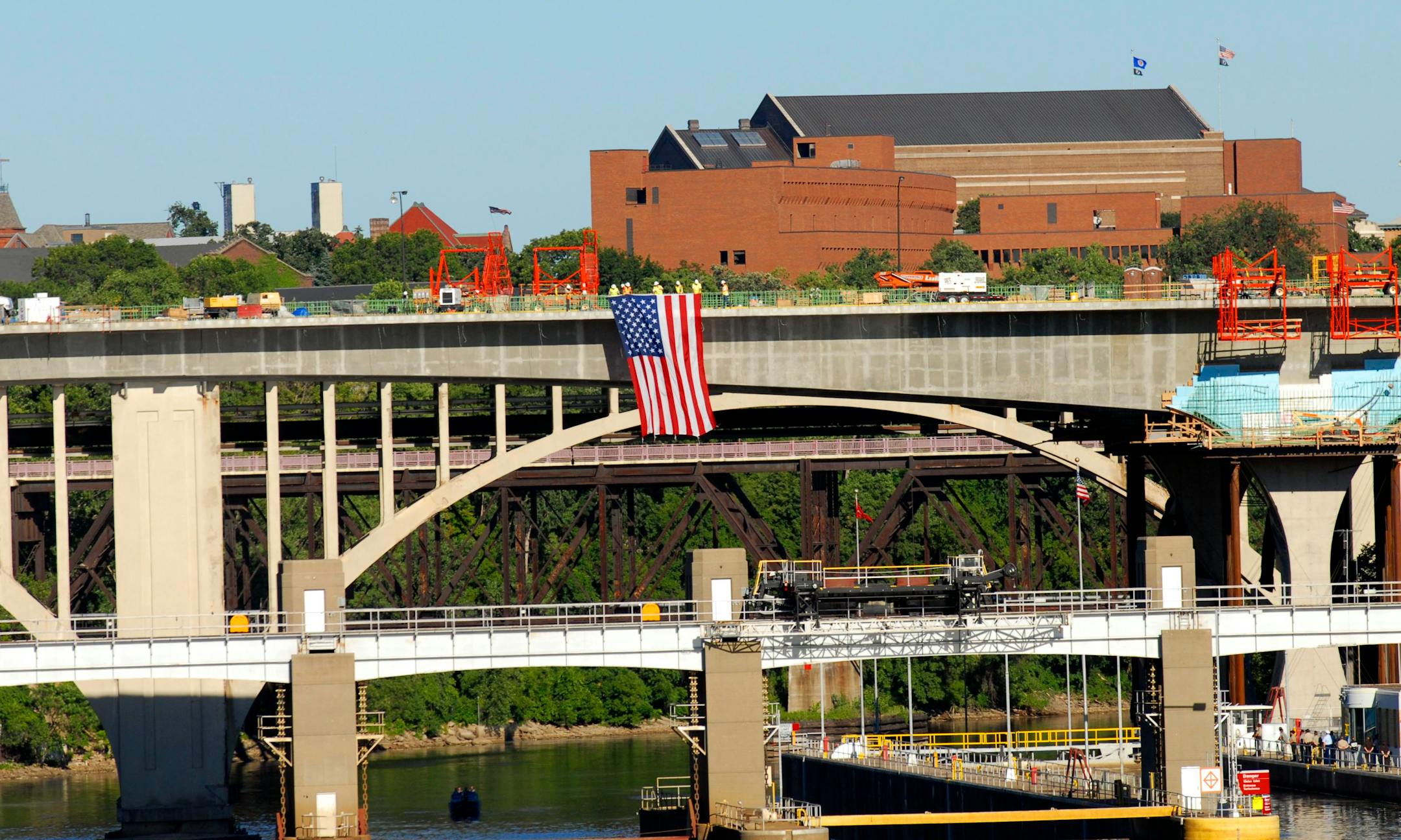 Construction workers unveiled an American flag from the new Interstate 35W bridge during a service marking the one-year anniversary of the bridge collapse.