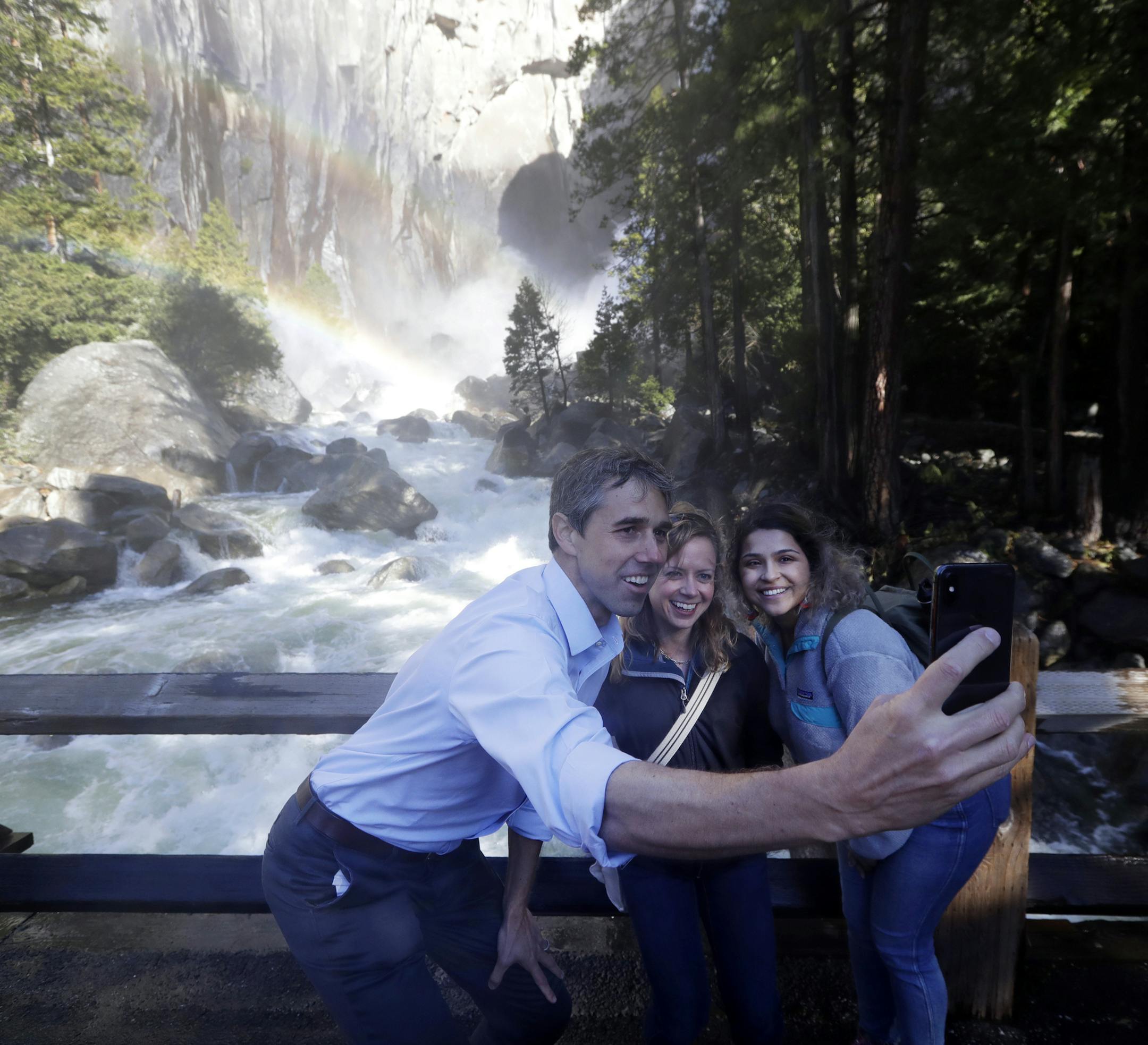 FILE - In a Monday, April 29, 2019 file photo, Democratic presidential candidate and former Texas congressman Beto O'Rourke, left, takes a selfie with Anne Kelly, center, Director of the Sierra Nevada Research Stations and environmental advocate Leslie Martinez, in Yosemite National Park, Calif. The Democrats who want to be president are swarming California, competing for campaign cash and media attention while courting longtime allies of home-state Sen. Kamala Harris on their rival’s own
