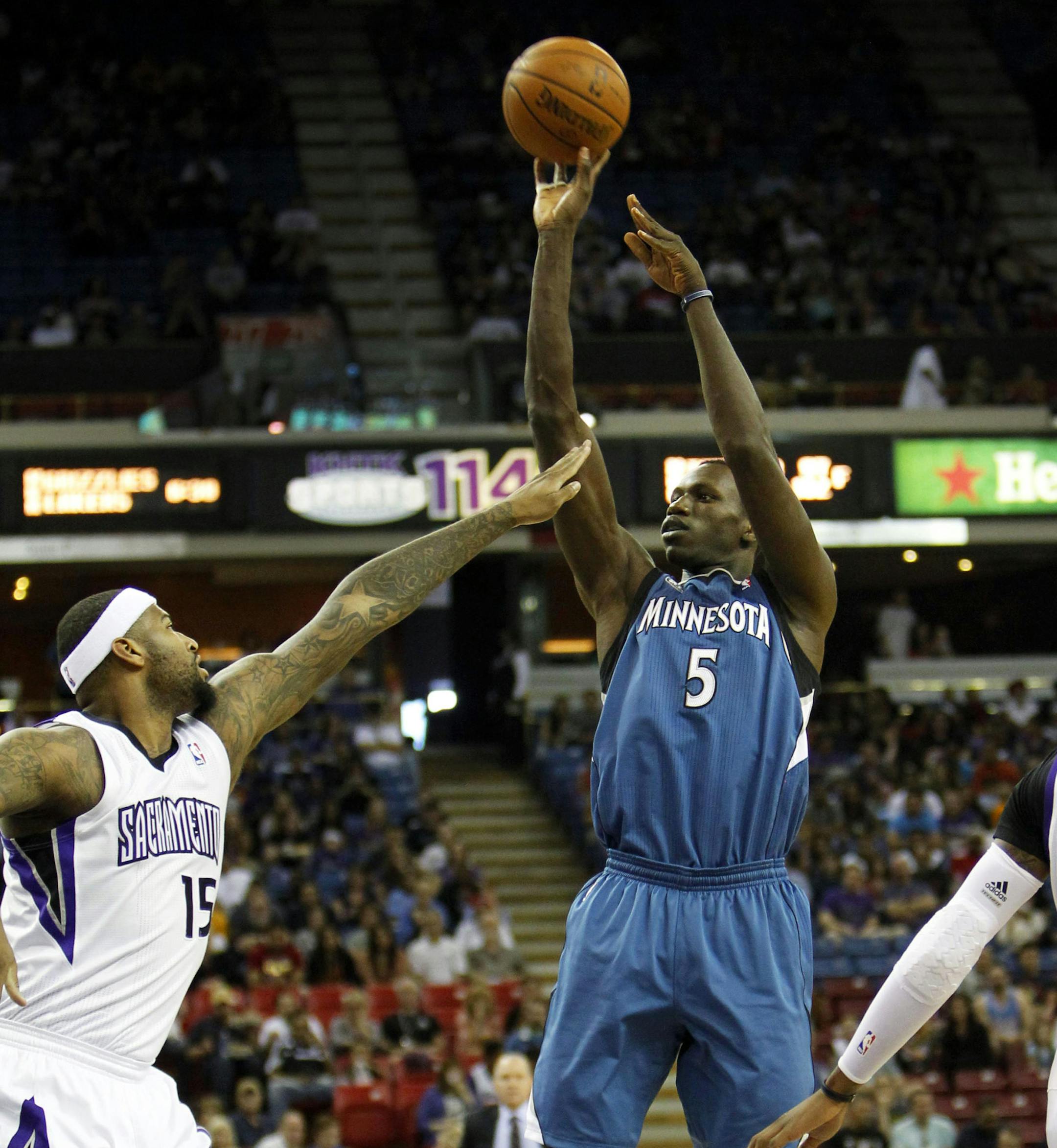 Minnesota Timberwolves center Gorgui Dieng (5) shoots over Sacramento Kings defender DeMarcus Cousins (15) during the first half of an NBA basketball game in Sacramento, Calif., on Sunday, April 13, 2014.(AP Photo/Steve Yeater)