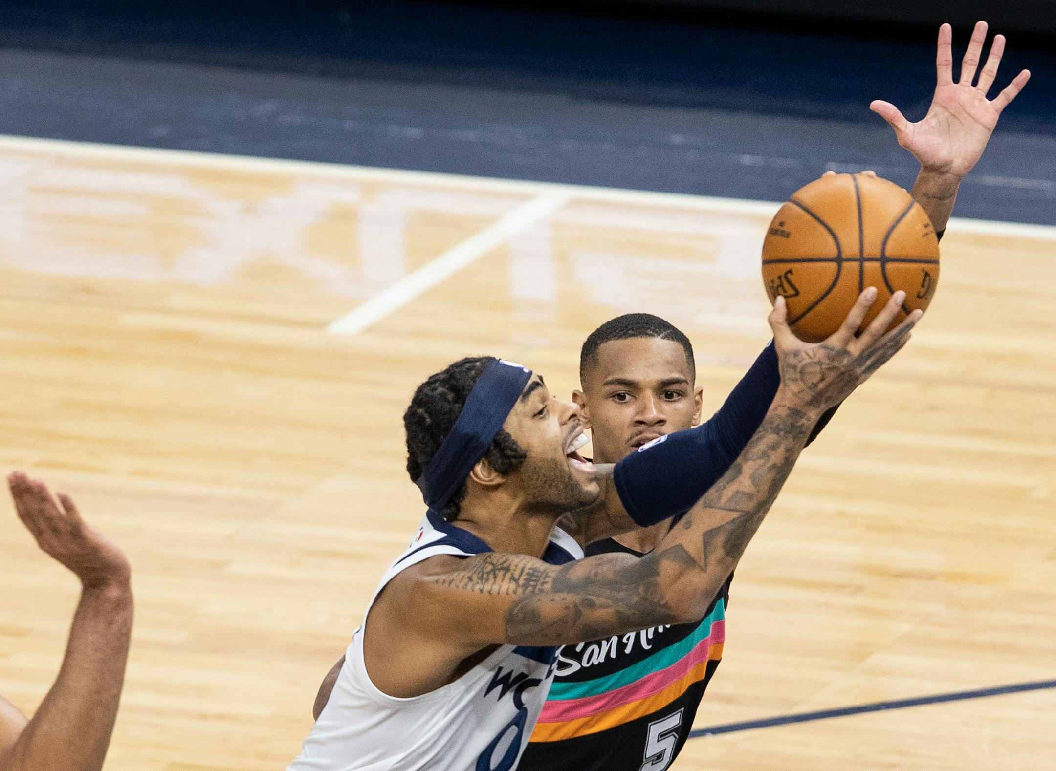 Minnesota Timberwolves D'Angelo Russell (0) was defended by Dejounte Murray (5) of the San Antonio Spurs in the third quarter.