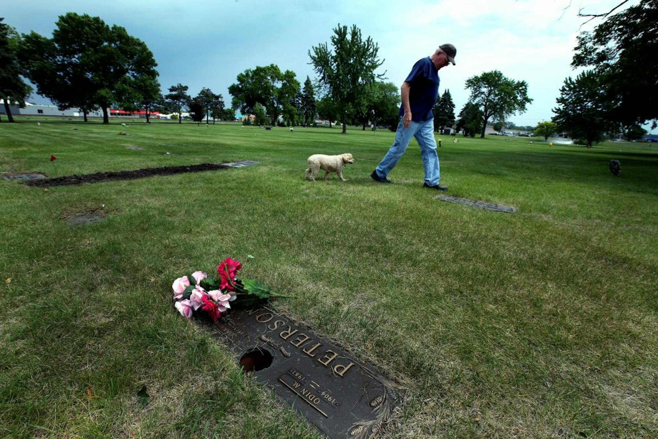 Ken Kersten of Owatonna, Minn., walked away from his wife's grave site at Glen Haven Memorial Gardens in Crystal. He buried his wife in the cemetery last week and then walked through on Wednesday, surprised to find gaping holes where bronze vases used to be.