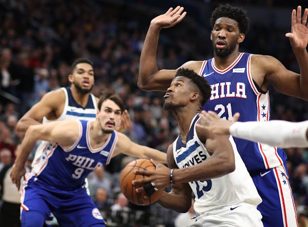 Minnesota Timberwolves guard Jimmy Butler (23) scored over Philadelphia 76ers center Joel Embiid (21) in the second half during NBA action at Target C