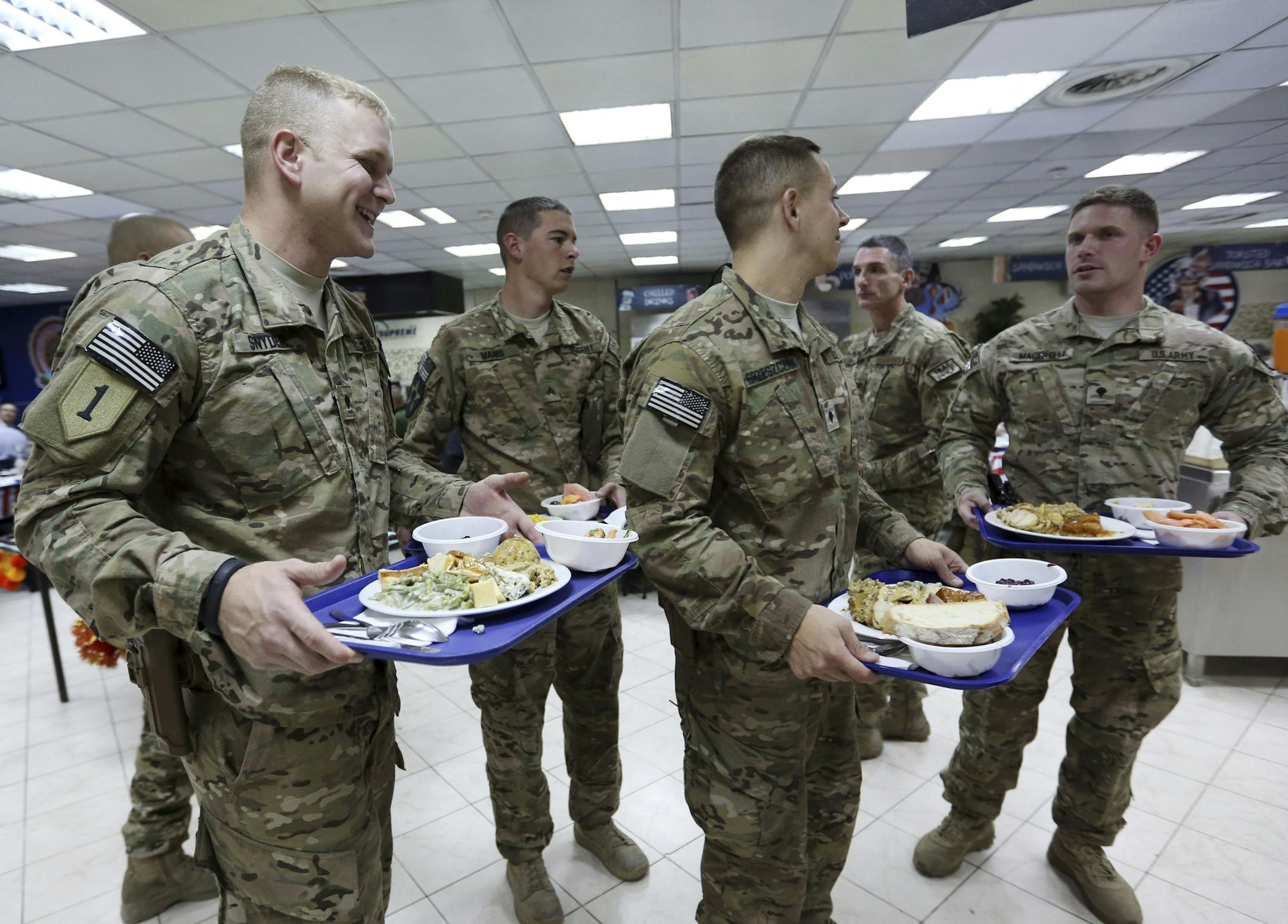 NATO soldiers carry their Thanksgiving Day meals at the ISAF headquarters in Kabul, Afghanistan, Thursday, Nov. 27, 2014. This is the last Thanksgiving cerebration before the U.S. and NATO combat mission ends on Dec. 31 this year. (AP Photo/Rahmat Gul)