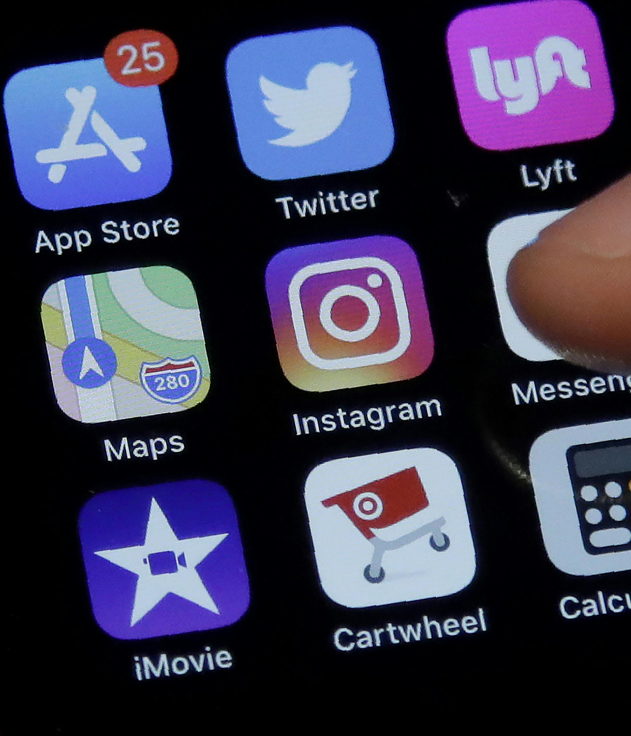 This July 10, 2019, photo shows an Associated Press reporter holding a phone showing the Instagram app icon in San Francisco. Instagram is expanding a test to hide how many &#x201c;likes&#x201d; people&#x2019;s posts receive on its photo-sharing app as it tries to combat criticism that such counts hurt mental health and make people feel bad when comparing themselves to others. (AP Photo/Jeff Chiu) ORG XMIT: NYBZ531