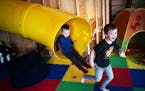 Leo Kuhl, with his friend Elliot Budziak, hop off the indoor slide, which travels from the upstairs mudroom down to the basement.