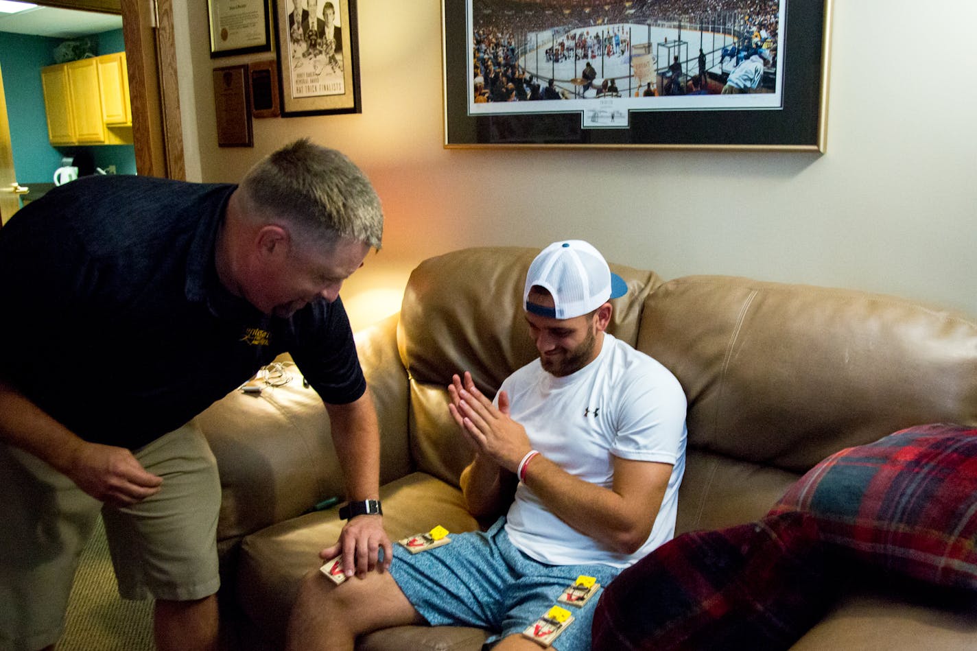 Mental skills coach Hans Skulstad removes mouse traps from Christian Horn's legs