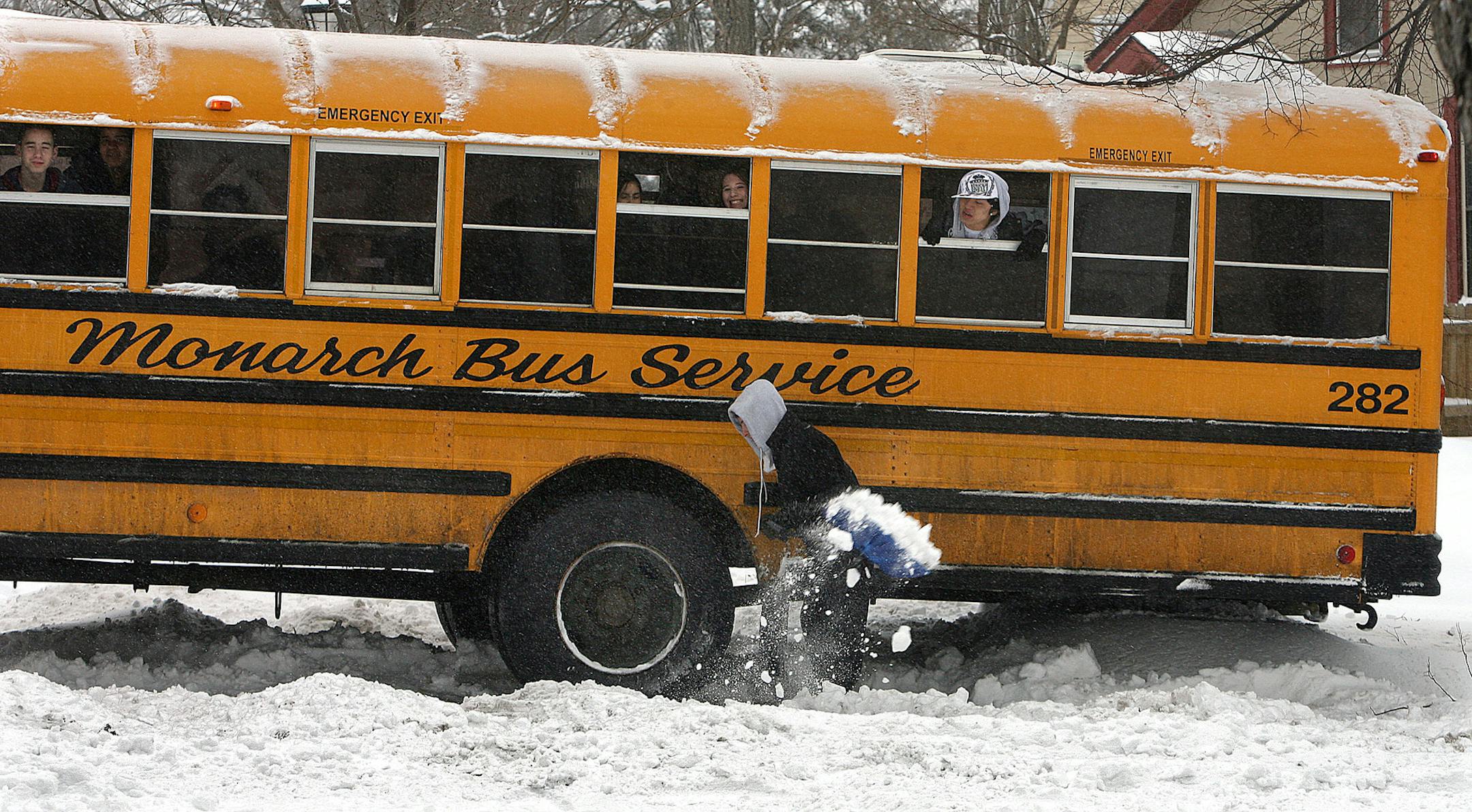 JIM GEHRZ ï james.gehrz@startribune.com St. Paul/February 26, 2009/4:00PM Andrew Miller, 23, stopped to help dig a school bus out of the snow Thursday afternoon at the intersection of McLean and Bates Avenues in St. Paul, as students from Highland Park Senior and Junior High Schools looked on. The bus was driven by Gerardo Carrillo, who managed to free the bus and continue his route.