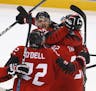 Maxim Noreau (56), of Canada, celebrates with his teammates after scoring a goal against Finland during the third period of the quarterfinal round of 