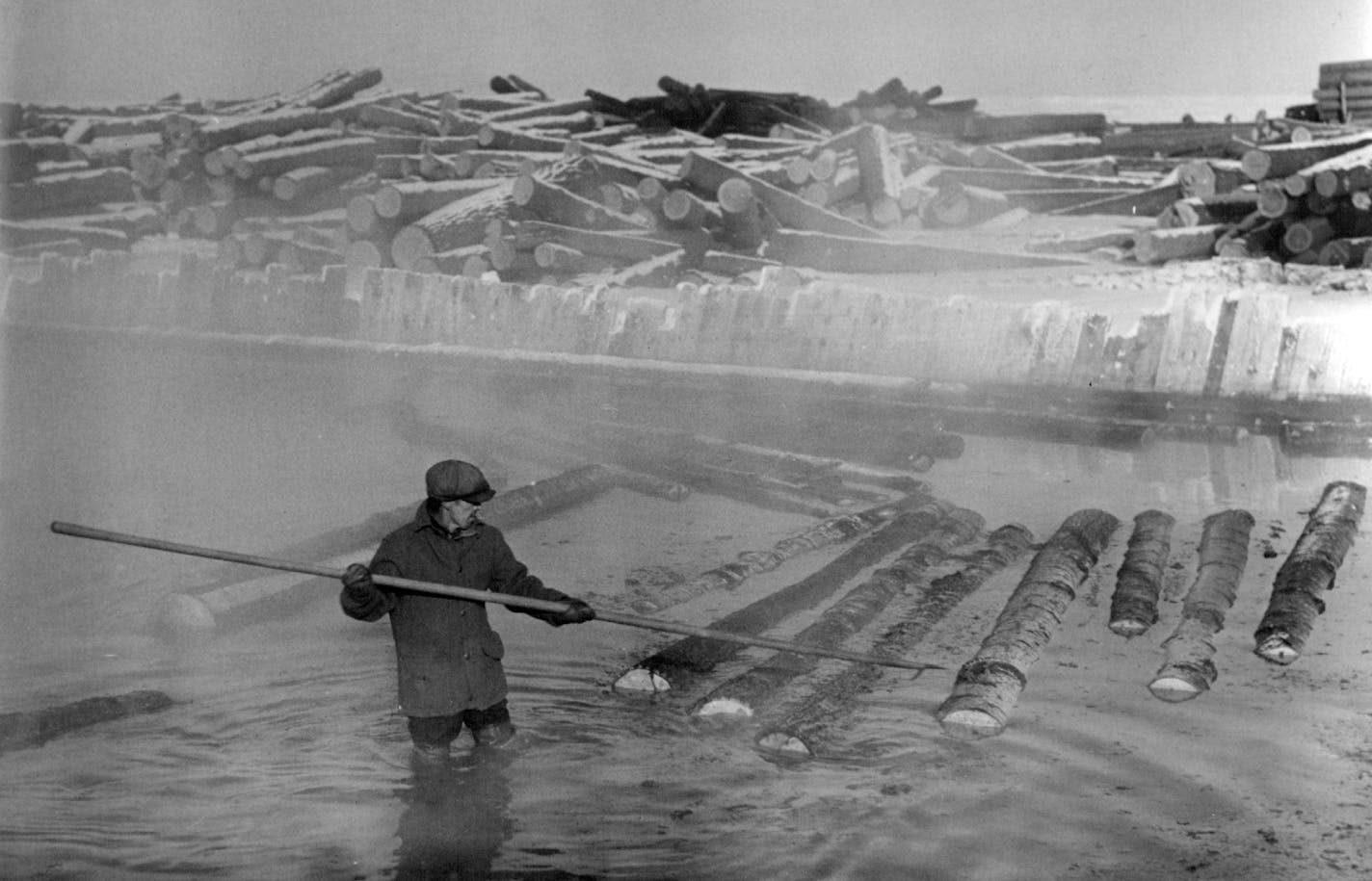 February 25, 1940 Hot pond at Redby on the Red Lake Indian Reservation.The logs are hauled from the logging camp by truck,dumped into the hot pond, and the logs hauled up a conveyor to the saw. The majority of logs are piled on the ice of the lake until It melts in the spring and are held together by booms when the water melts.The hot pond is kept from freezing by steam. Minneapolis Star Journal ORG XMIT: MIN2018113013161353