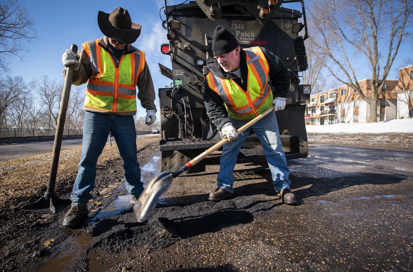 Street service workers Bradley Therres, left, and Lance Hamby fill potholes on Shepard Road. ] LEILA NAVIDI &#xa5; leila.navidi@startribune.com BACKGROUND INFORMATION: St. Paul Public Works street service workers patch potholes with asphalt on Shepard Road near Homer Street in St. Paul on Friday, March 15, 2019.