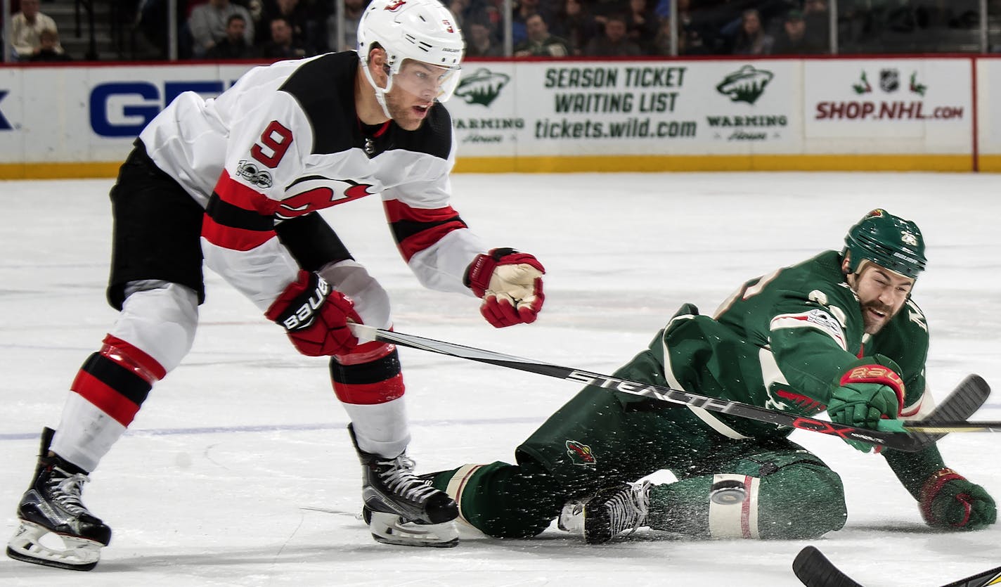 The Devils' Taylor Hall (9) and the Wild's Daniel Winnik fought for the puck in the first period.