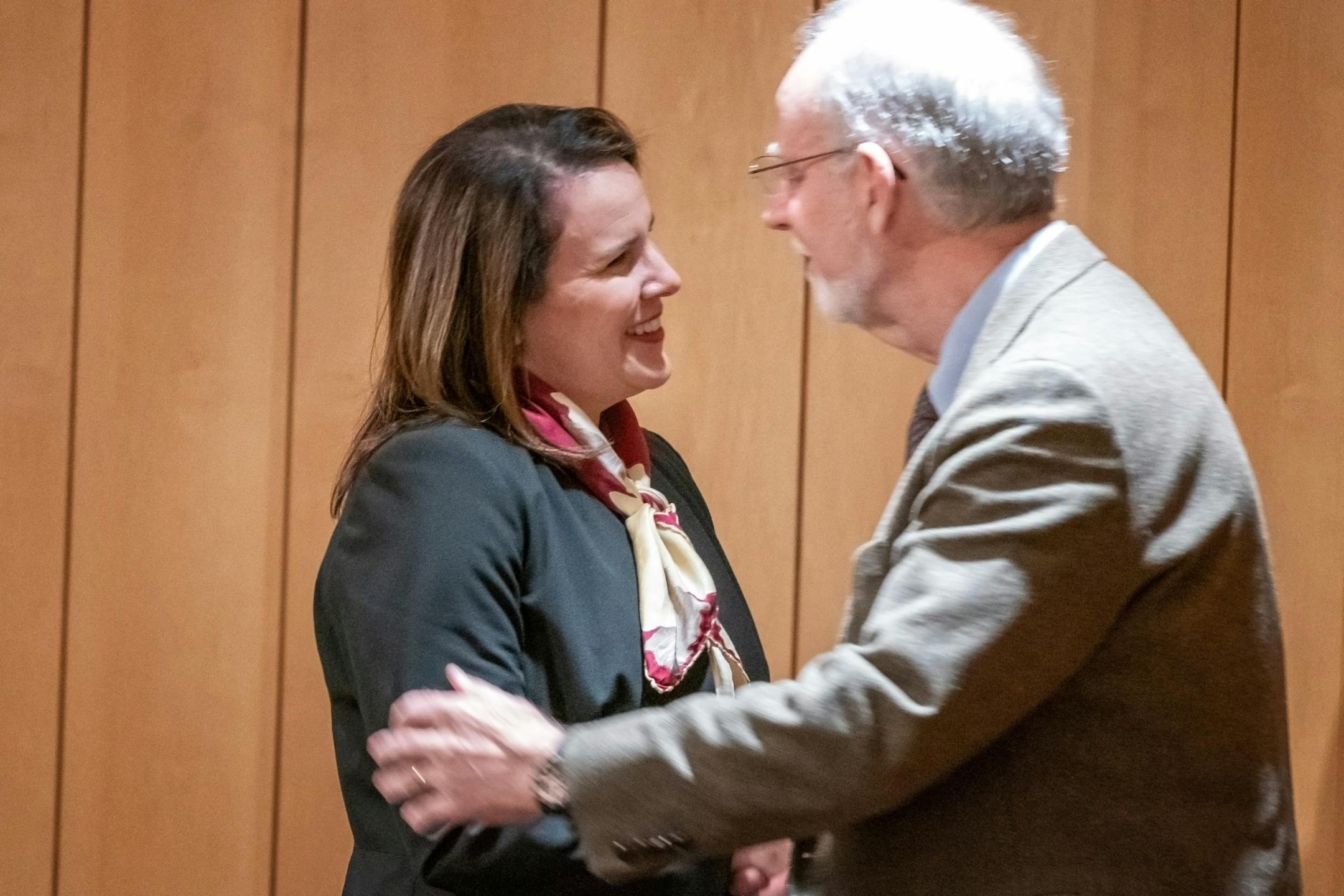 Joan Gabel rose to greet members of the Board of Regents after they unanimously voted to hire her as the university's first female president. Here she greeted Kendall J. Powell, Vice Chair of the Board.