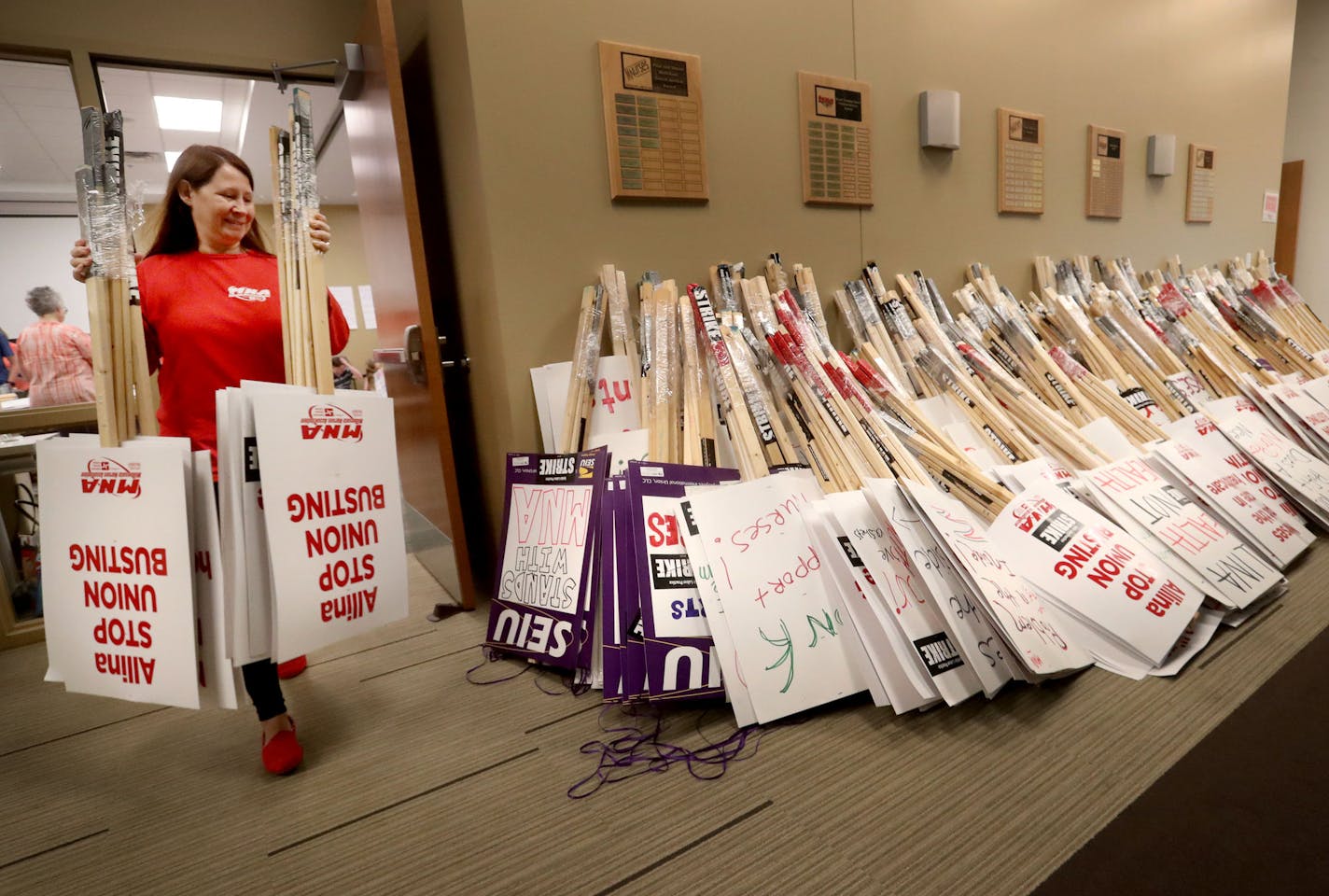 Valerie Johnson, an RN at Abbott Northwestern Hospital, added to the pile as MNA nurses, Minnesota Nurses Association employees and family members joined forces at the MNA headquarters to make posters for picketing Saturday, June 18, 2016, should a strike happen Sunday at five Twin Cities Allina Health facilities. Cooper' mother Shannon Cunningham is a MNA employee.](DAVID JOLES/STARTRIBUNE)djoles@startribune For the second time in six years, the Twin Cities is on the brink of a major national n