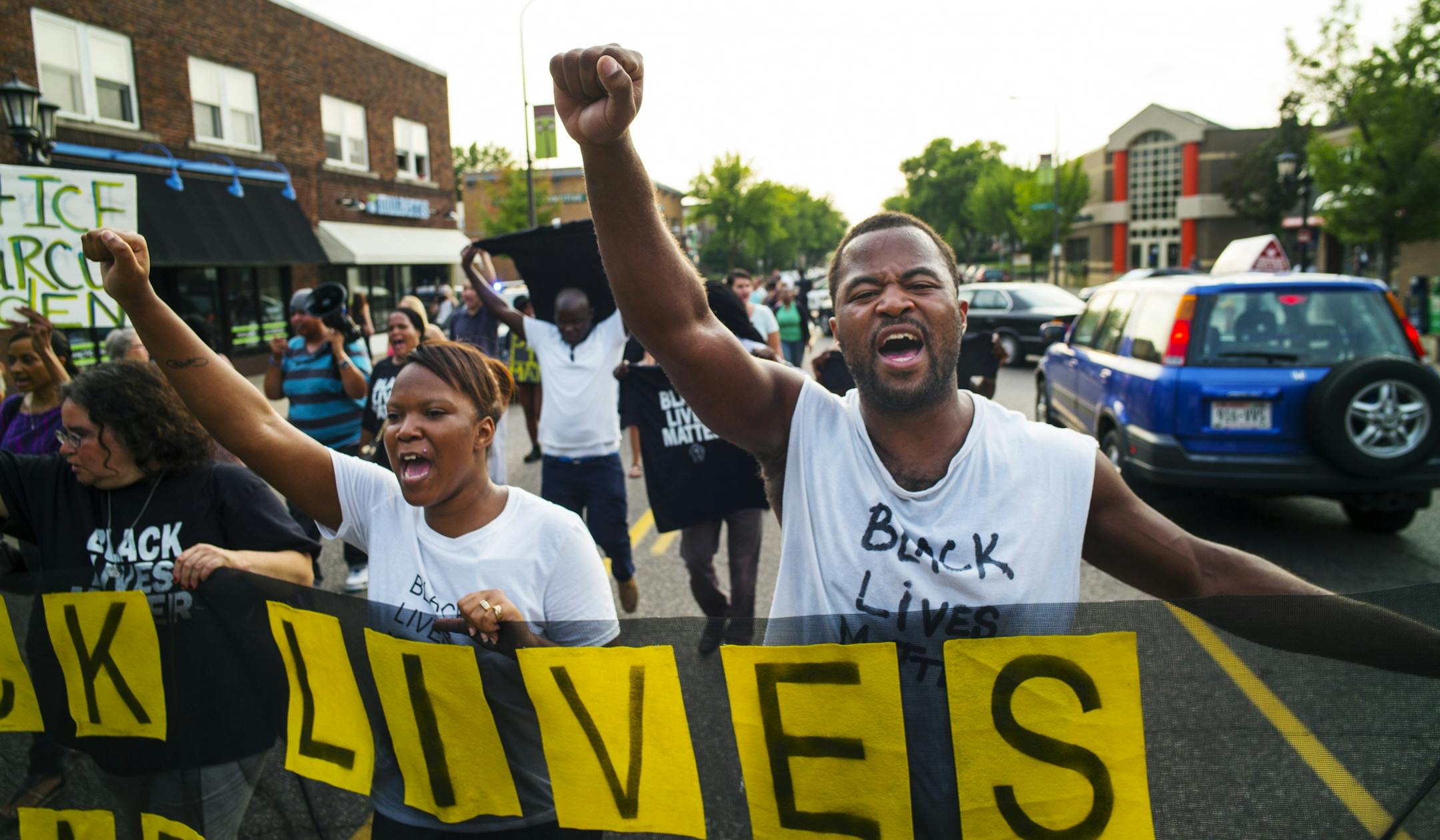 Protest leader, Rashad Turner, far right, leads dozens of protesters in a Black Lives Matter rally in the neighborhood around Governor's Mansion in St. Paul, Minn. (Richard Tsong-Taatarii /Star Tribune via AP) MANDATORY CREDIT; ST. PAUL PIONEER PRESS OUT; MAGS OUT; TWIN CITIES LOCAL TELEVISION OUT