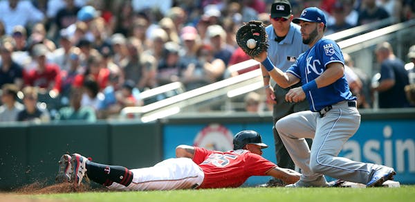 Minnesota Twins center fielder Byron Buxton (25) is safe on a pick off attempt in the second inning , as Kansas City Royals first baseman Eric Hosmer 