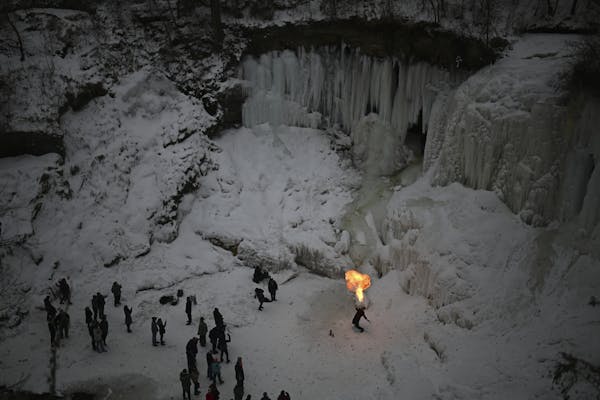Adam Solko, a professional fire performer, breathed flames at the base of frozen Minnehaha Falls Saturday.