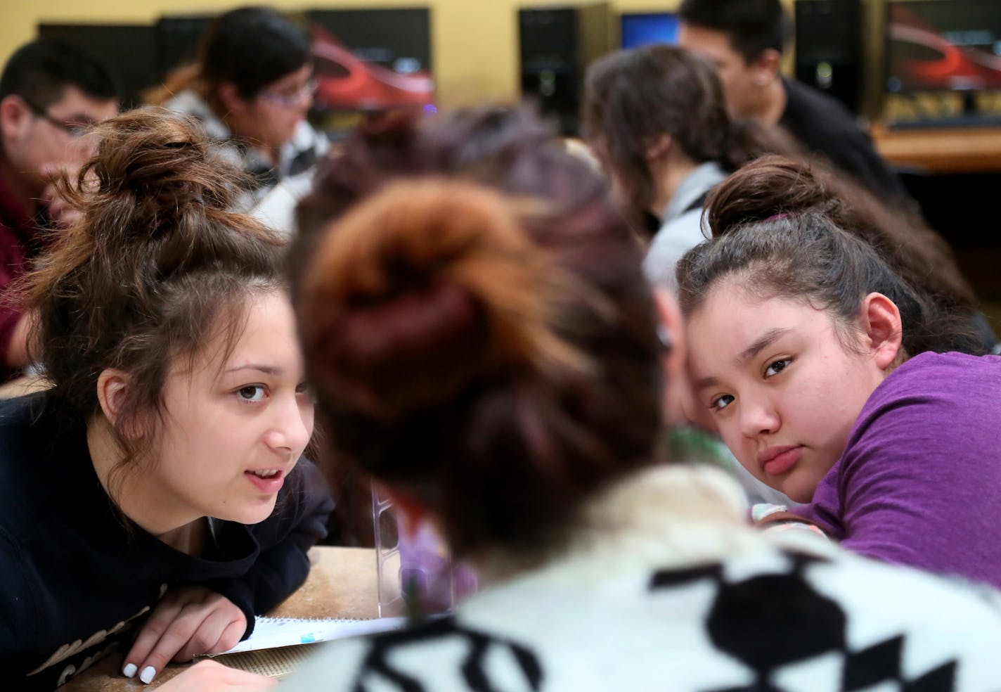 Language arts students Esperanza Garcia, left, and Shannell Pineda, right, both freshman, have a conference with their teacher Megan Nagel, as other students read from John Steinbeck's"Of Mice and Men," at El Colegio Charter School, where the graduation rate has more than doubled since last year, Tuesday, Feb. 24, 2015, in Minneapolis, MN.] (DAVID JOLES/STARTRIBUNE)djoles@startribune.com El Colegio Charter School: The largest increase statewide in grad rates since last year. More than doubled it