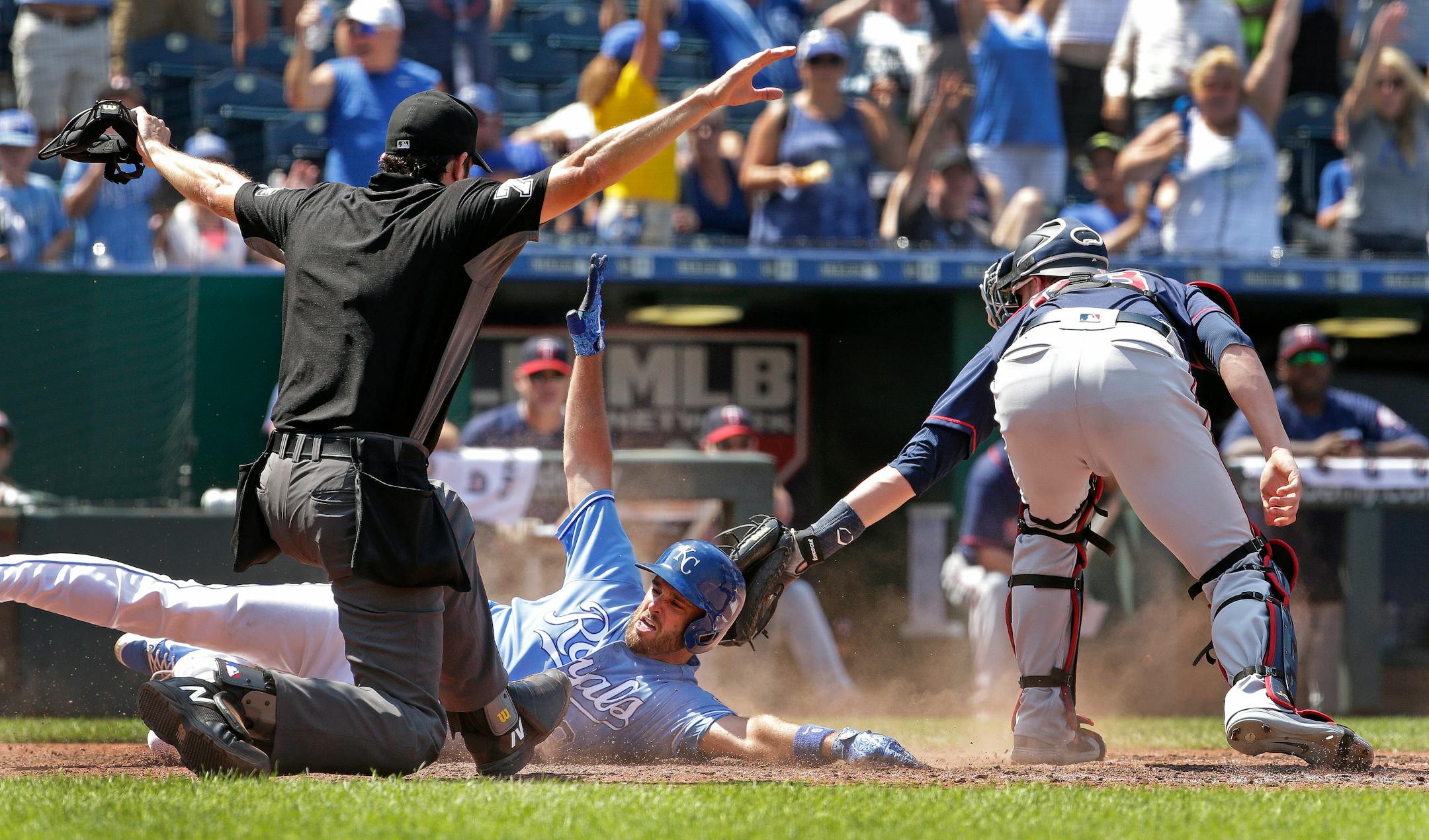 The Royals' Drew Butera slid into home ahead of the tag of Twins catcher Mitch Garver after hitting a three-run, inside-the-park home run during the seventh inning Sunday.