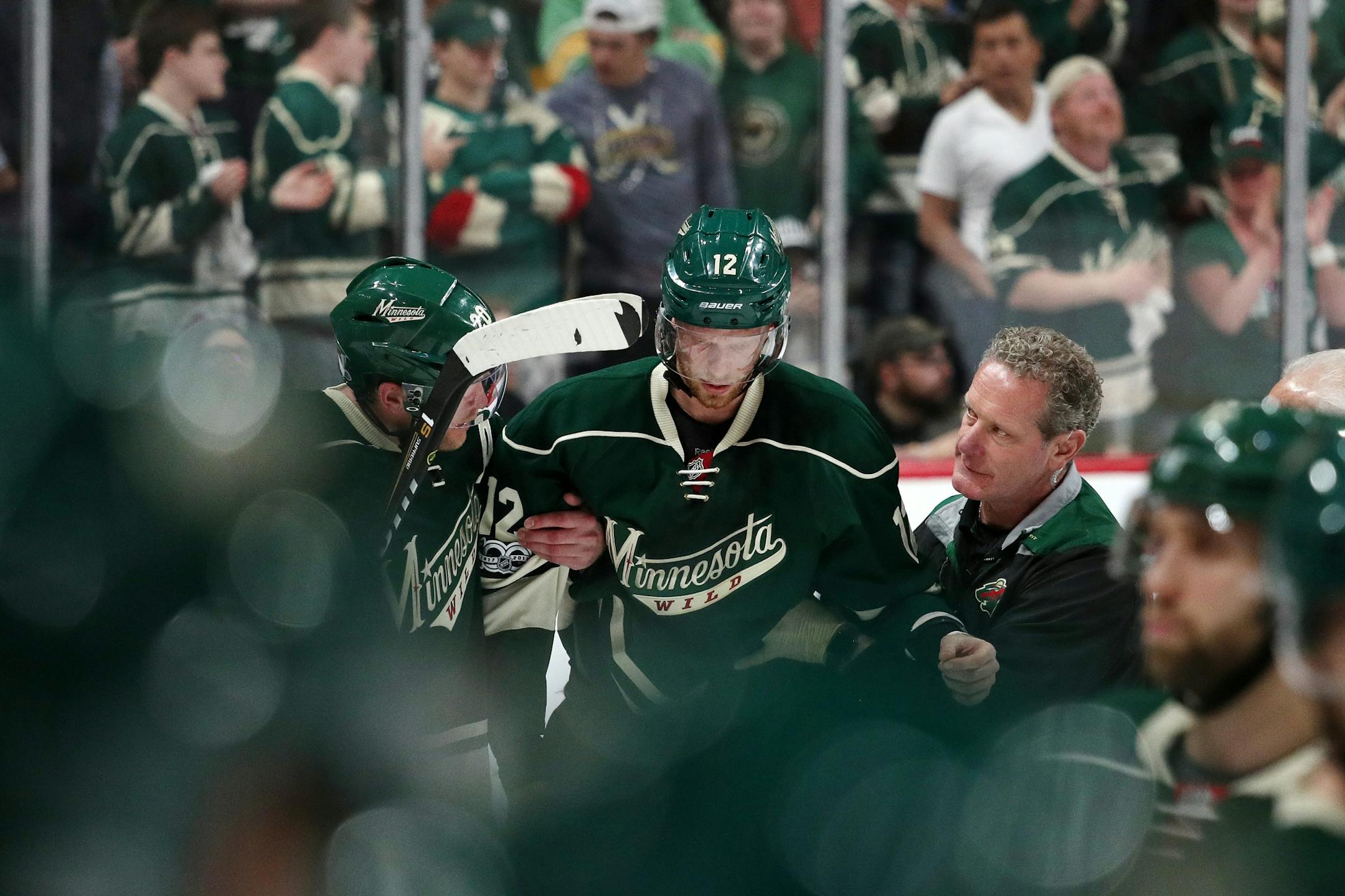 Minnesota Wild center Eric Staal (12) was helped off the ice after suffering an injury from crashing into the boards in the second period.