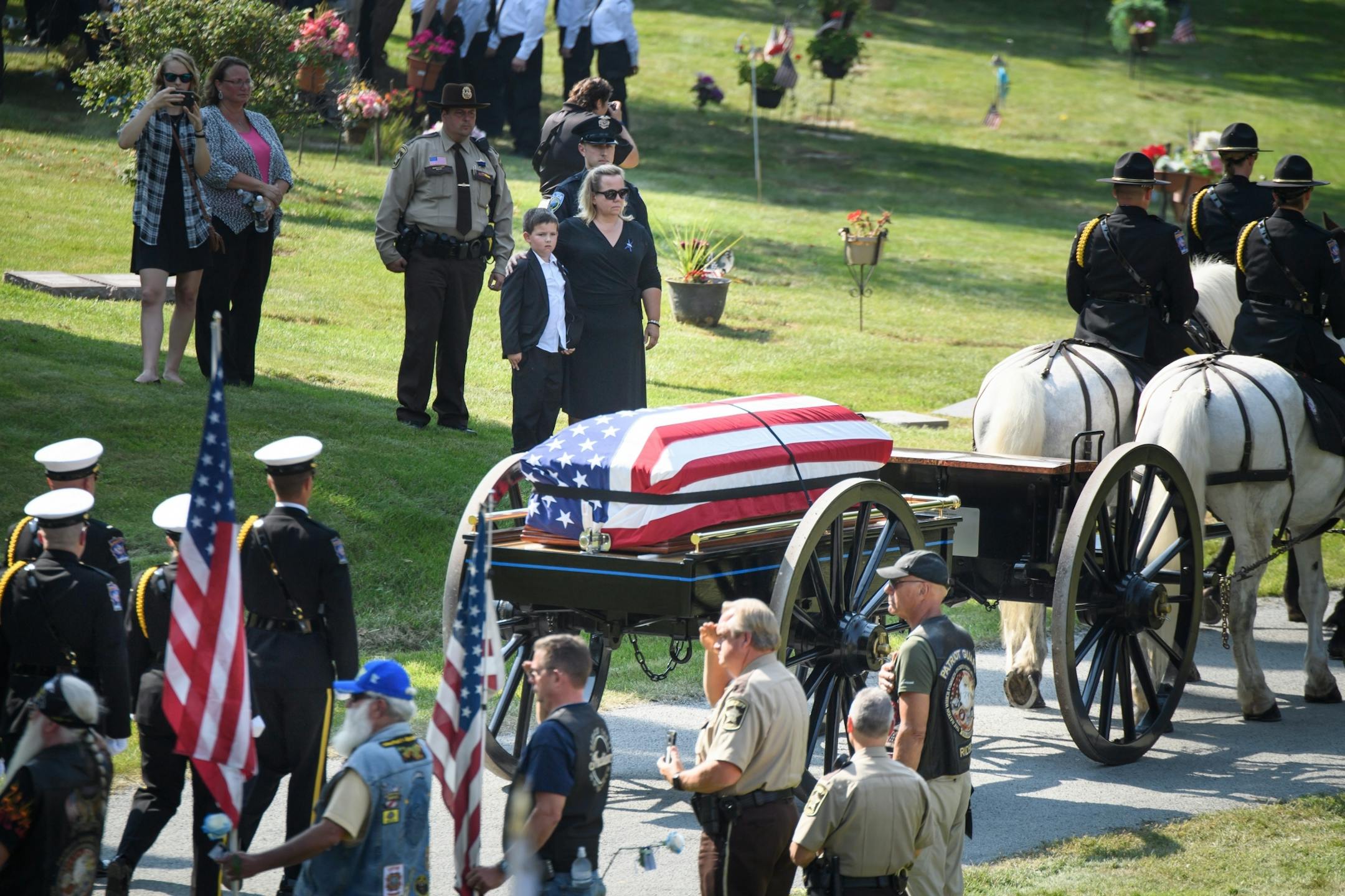 Shawn Mathews and her son Wyatt watched as her husband's casket arrives for burial ceremony at Summit Park Cemetery.
