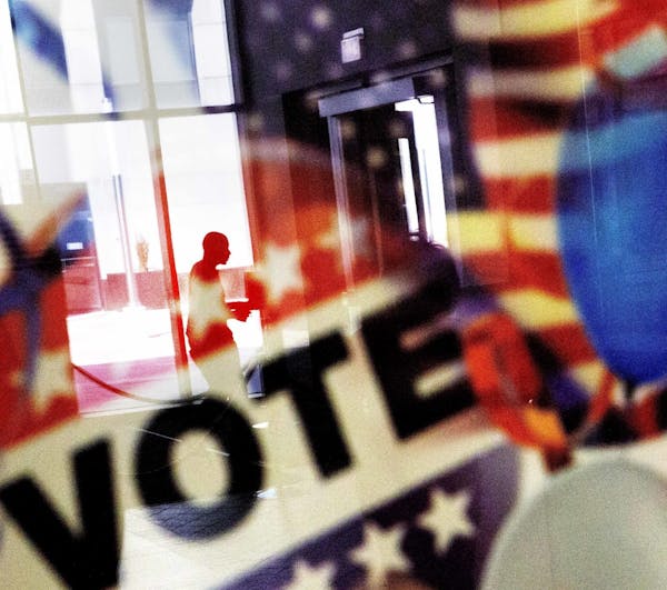 A voter is reflected in glass at a voting site in this file photo.