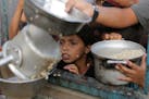 A Palestinian boy watches his portion of food aid ahead of the upcoming Eid al-Adha holiday in Khan Younis, Saturday, June 15, 2024.