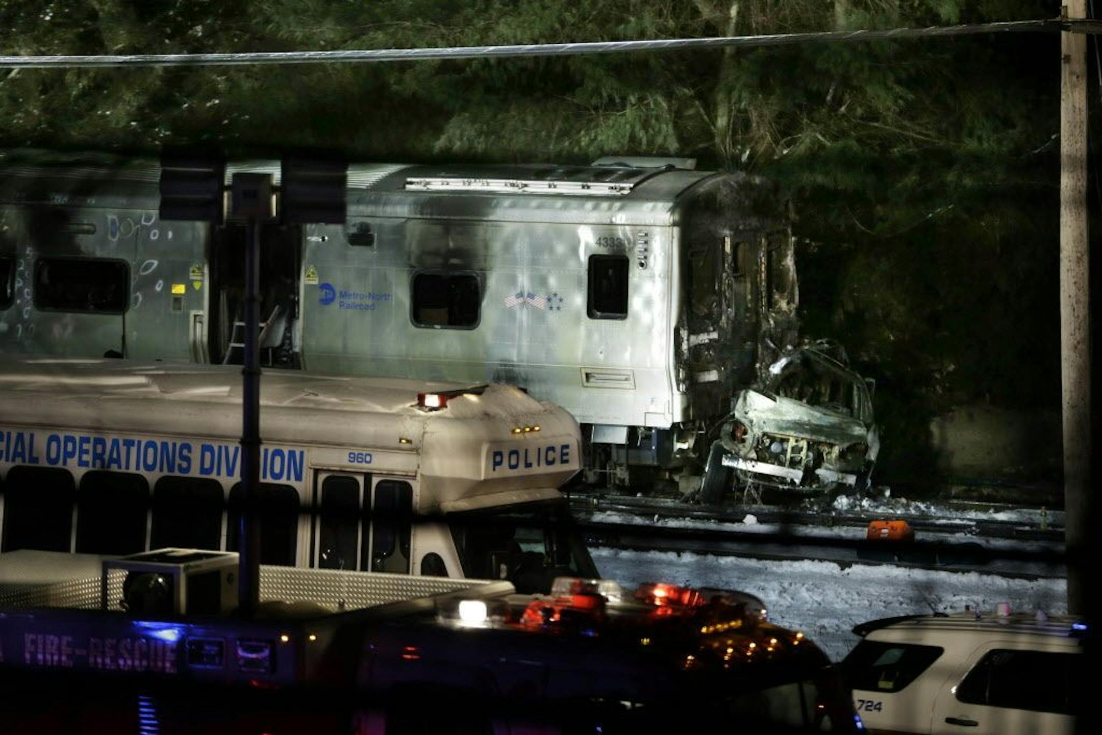 The wreckage of a car remains smashed against the front of a train in Valhalla, N.Y., Tuesday, Feb. 3, 2015.