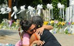 Stewart Watson, right, of Baltimore, comforts Maranda Mincey ofCharleston, as they both become emotional while visiting the sidewalk memorial at the E