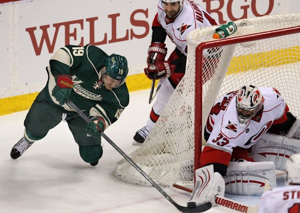 Wild Stephane Veilleux, 19, tries to stuff one into the goal against Carolina goalie, Brian Boucher, 33, in the first period.