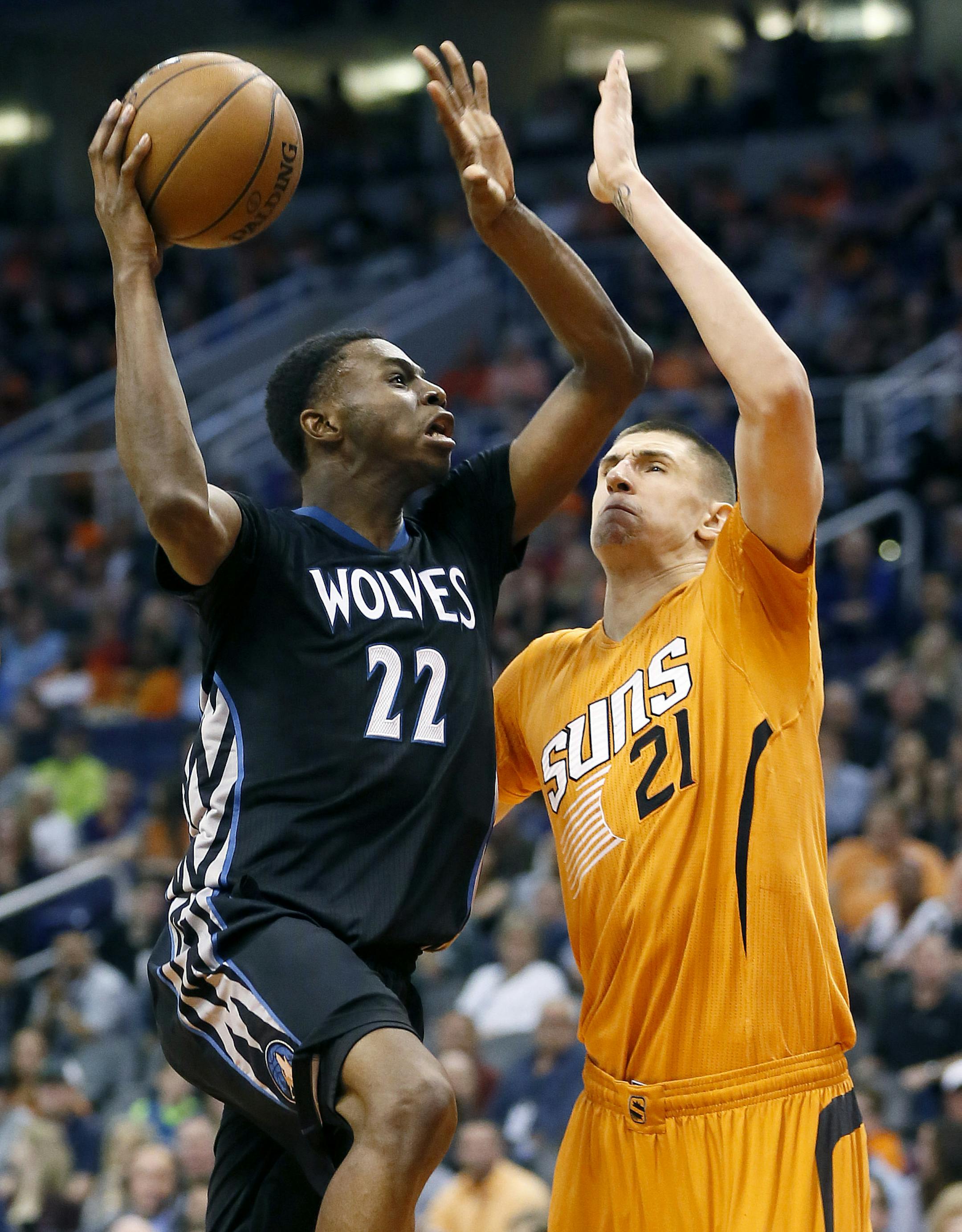 Minnesota Timberwolves' Andrew Wiggins (22) shoots over Phoenix Suns' Alex Len (21) during the first half of an NBA basketball game, Friday, Jan. 16, 2015, in Phoenix. (AP Photo/Matt York)