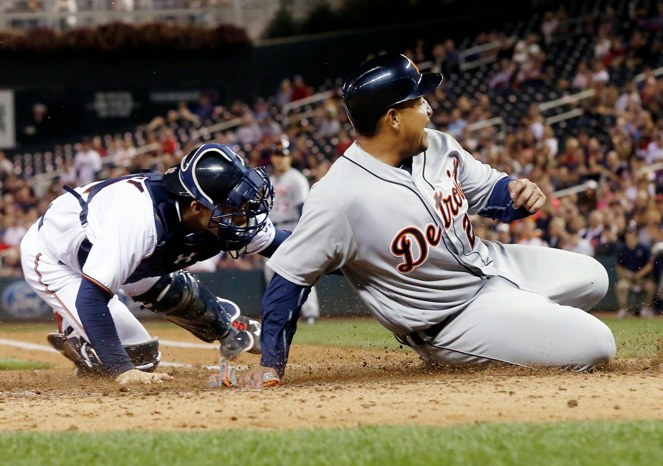 Detroit's Miguel Cabrera slid home safely as Twins catcher John Ryan Murphy tried to apply the tag in the fourth inning Tuesday night at Target Field. Cabrera was first called out, but the call was reversed on review.