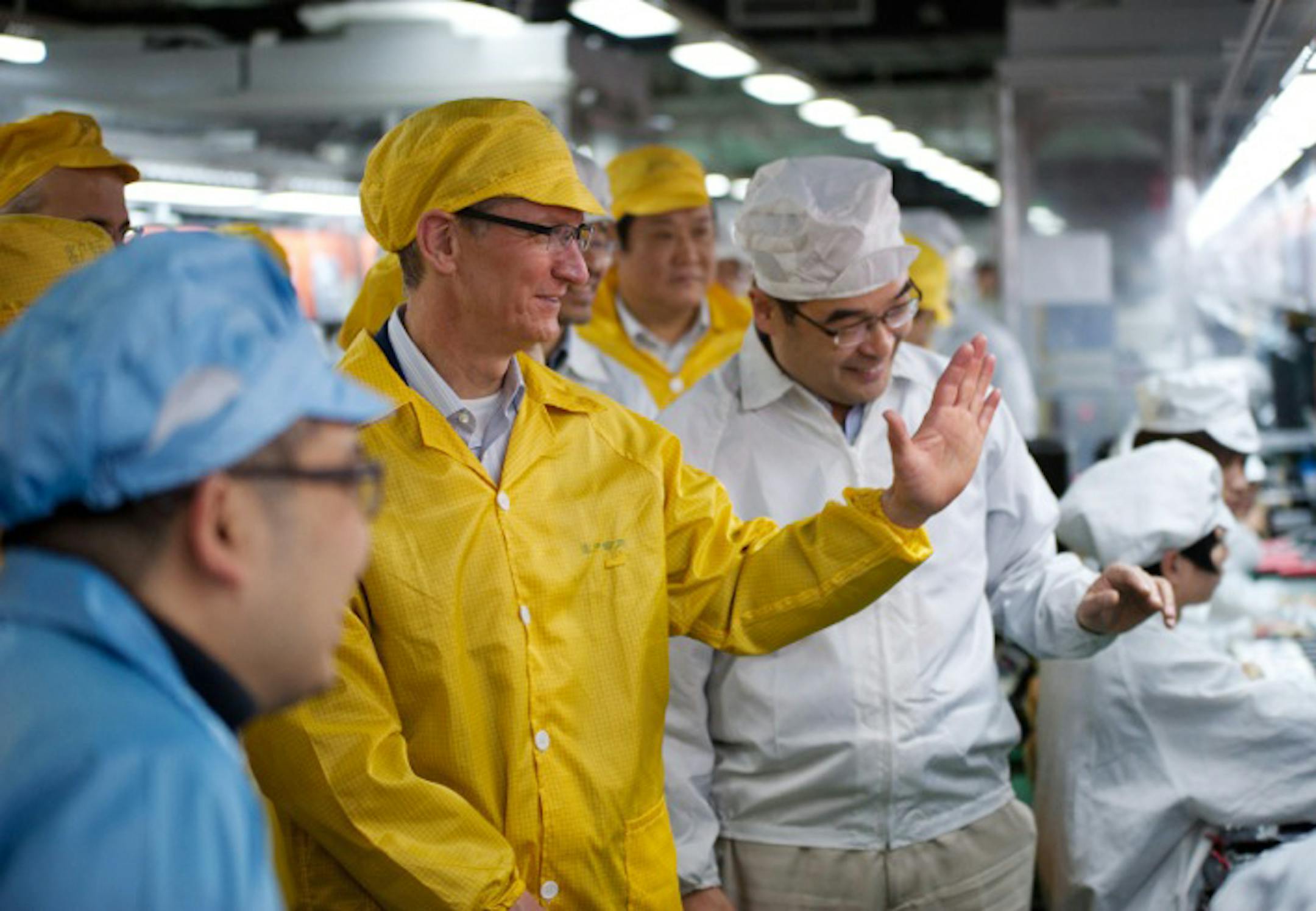 In this March 28, 2012 photo provided by Apple, Inc., Apple CEO Tim Cook, center, visits the iPhone production line at the newly-built manufacturing facility Foxconn Zhengzhou Technology Park, which employs 120,000 people. A report released Thursday, March 29, by the Washington-based Fair Labor Association says Hon Hai Precision Industry Co., the Taiwanese company that runs Apple's factories in mainland China, has committed to reducing weekly work time to the legal Chinese maximum of 49 hours. (