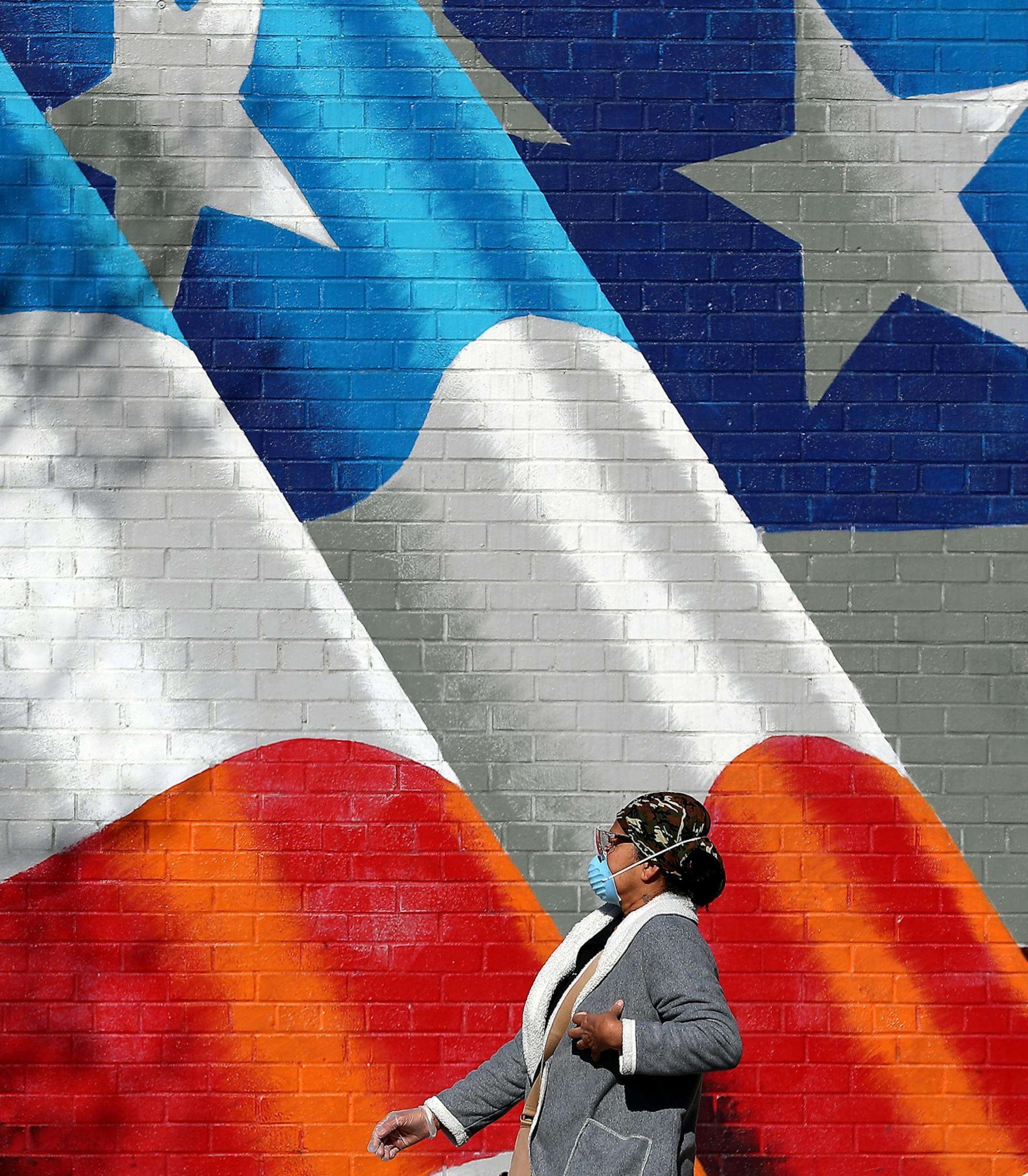 A pedestrian walked by an American flag mural painted on the side of the Uptown VFW along Lyndale Avenue S., near Lake Street Tuesday, April 21, 2020, In Minneapolis, MN.