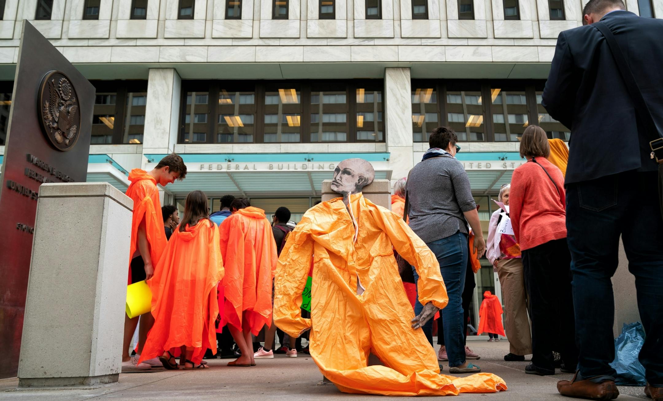Protesters wore orange ponchos in solidarity with the three men being who were convicted in plotting to join ISIS. The men are appearing before a three-judge federal appeals court panel Thursday morning. Protesters were not allowed to enter the courthouse until the orange ponchos and signs bearing the names of the convicted men were removed.