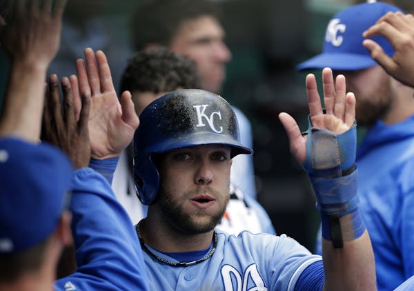 Kansas City Royals' Alex Gordon celebrates in the dugout with teammates after scoring on a double by Billy Butler during the first inning of a basebal