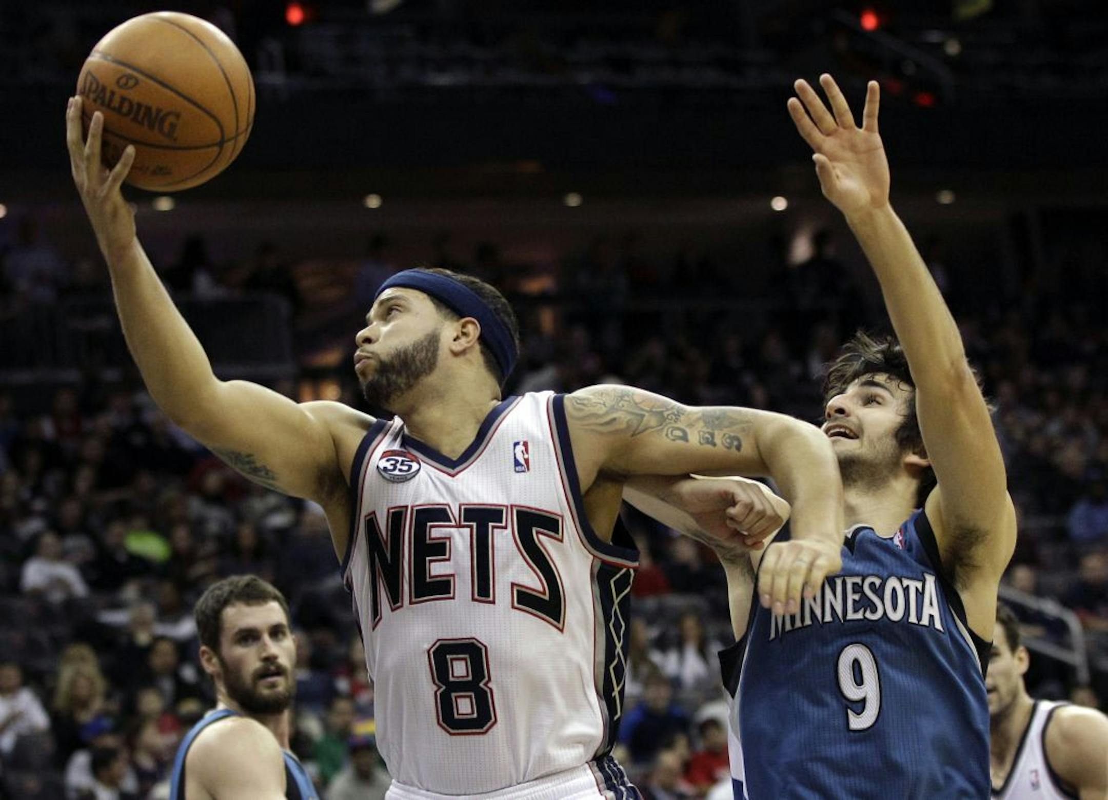 New Jersey Nets' Deron Williams (8) takes a shot as he holds off Minnesota Timberwolves Ricky Rubio (9), of Spain, during the first quarter of an NBA basketball game in Newark, N.J., Friday, Feb. 3, 2012.
