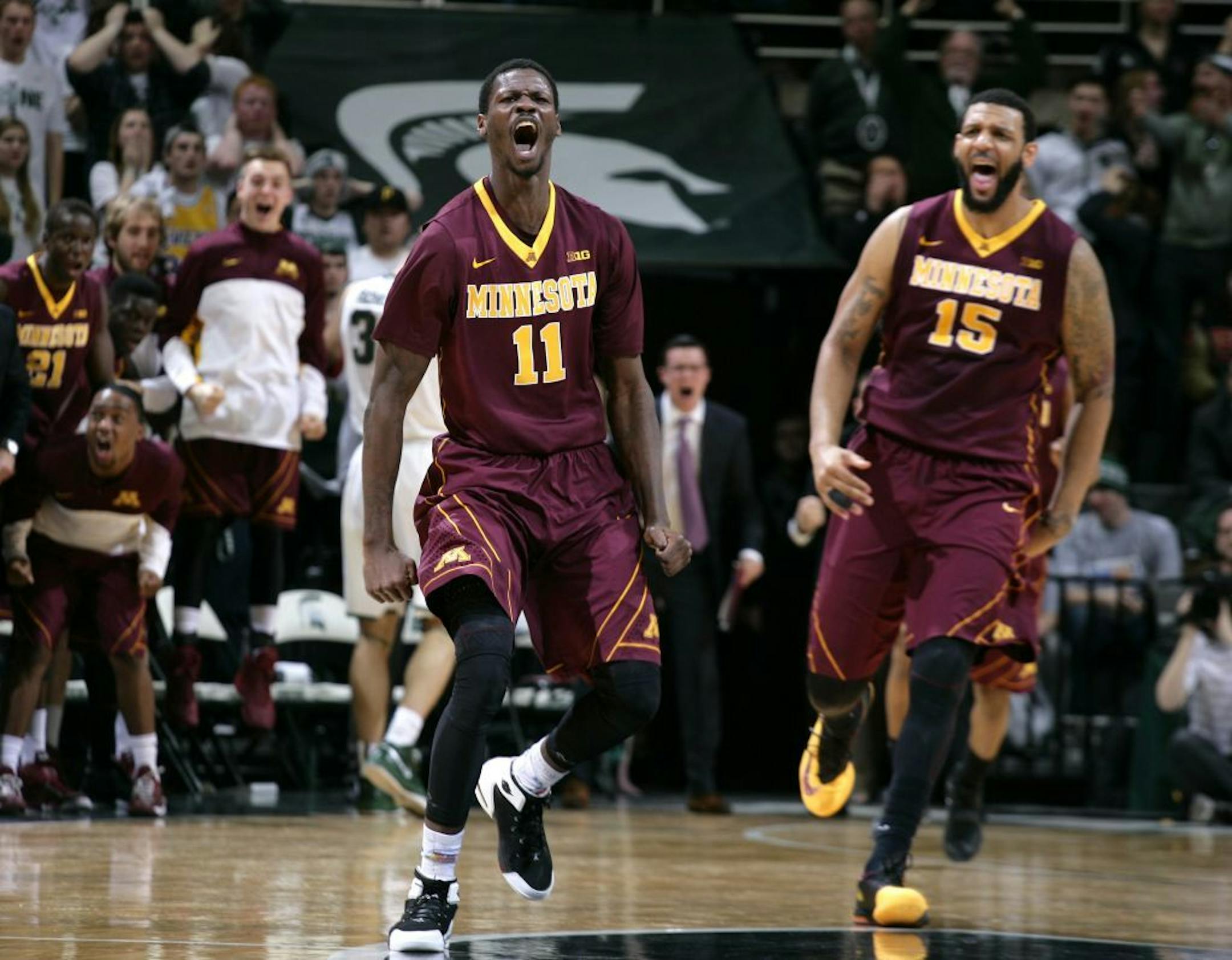 Minnesota's Carlos Morris (11) and Maurice Walker (15) celebrate after Morris hit a 3-pointer with seconds remaining in the second half to force overtime in an NCAA college basketball game against Michigan State, Thursday, Feb. 26, 2015, in East Lansing, Mich. Minnesota won 96-90 in overtime.