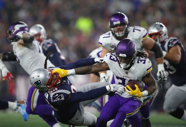 Minnesota Vikings running back Dalvin Cook (33) held off New England Patriots defensive end Adrian Clayborn (94) while ultimately gaining nothing on a
