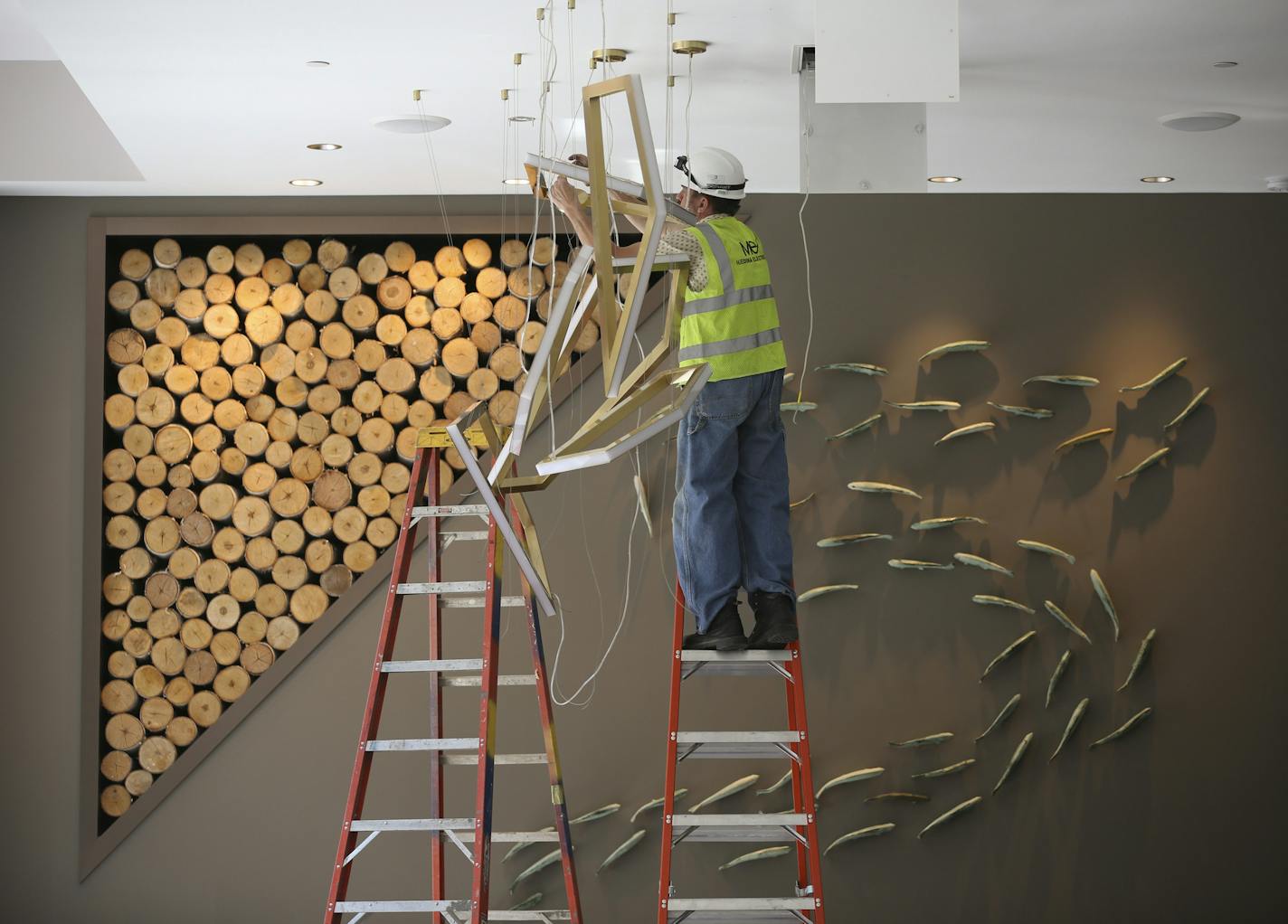 An electrician installed a light fixture in the lobby of the new Embassy Suites hotel Monday afternoon. ] JEFF WHEELER &#xef; jeff.wheeler@startribune.com A new Embassy Suites hotel is slated to open this week in the Plymouth Building at S. 6th St. and Hennepin Ave. in downtown Minneapolis. In the coming months more than 1000 new hotel rooms from six different projects will be coming online. Interiors of the Embassy Suites were photographed Monday, August 22, 2016.