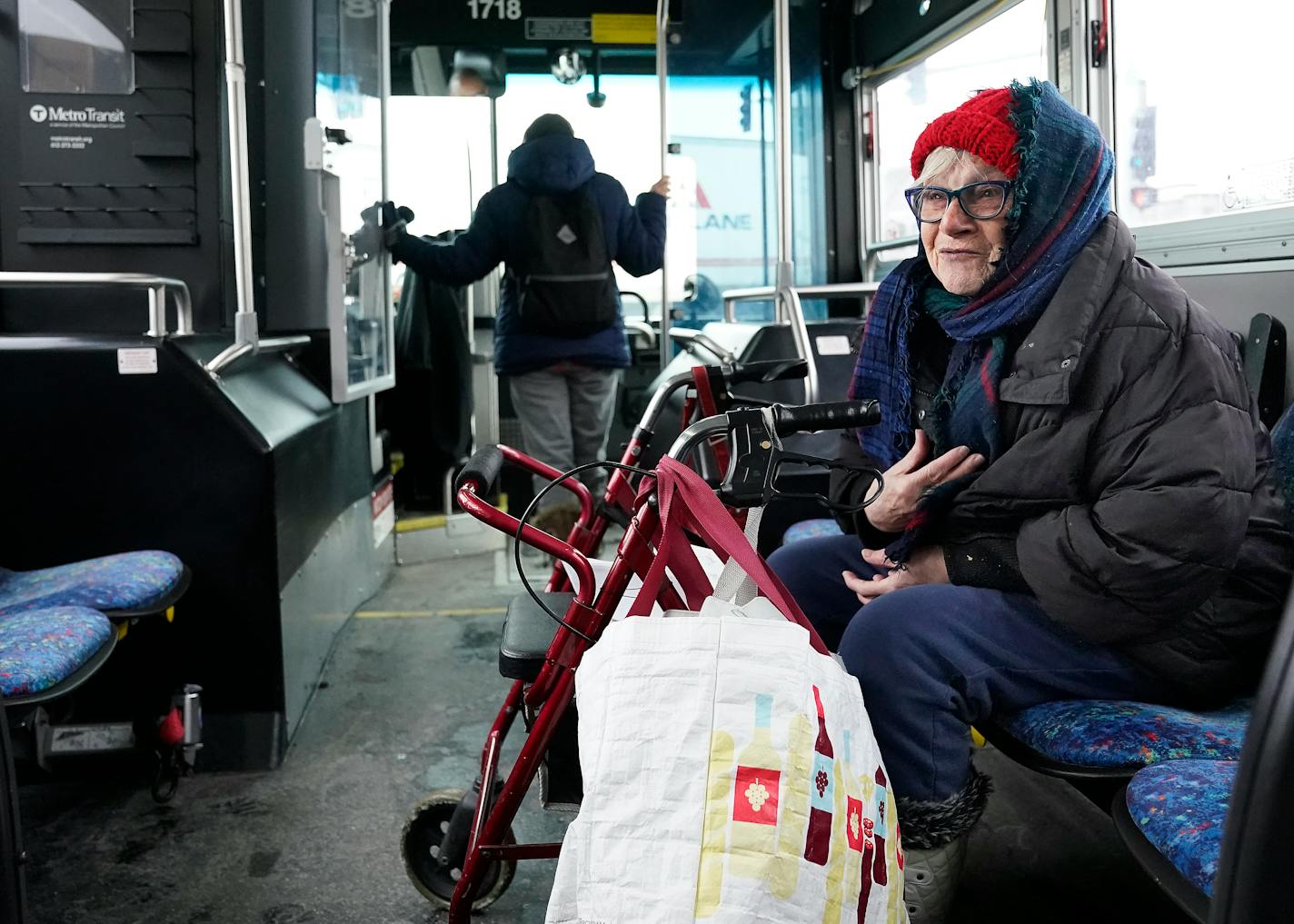 Joy Rindels-Hayden, 86, is waging a prolonged campaign to pass a state law to improve bus safety during the dangerous winter months after she suffered a near-debilitating brain injury years ago while getting off a metro bus and was seen riding a bus to a food pantry Friday, Jan. 13, 2023 in Minneapolis, Minn. ]