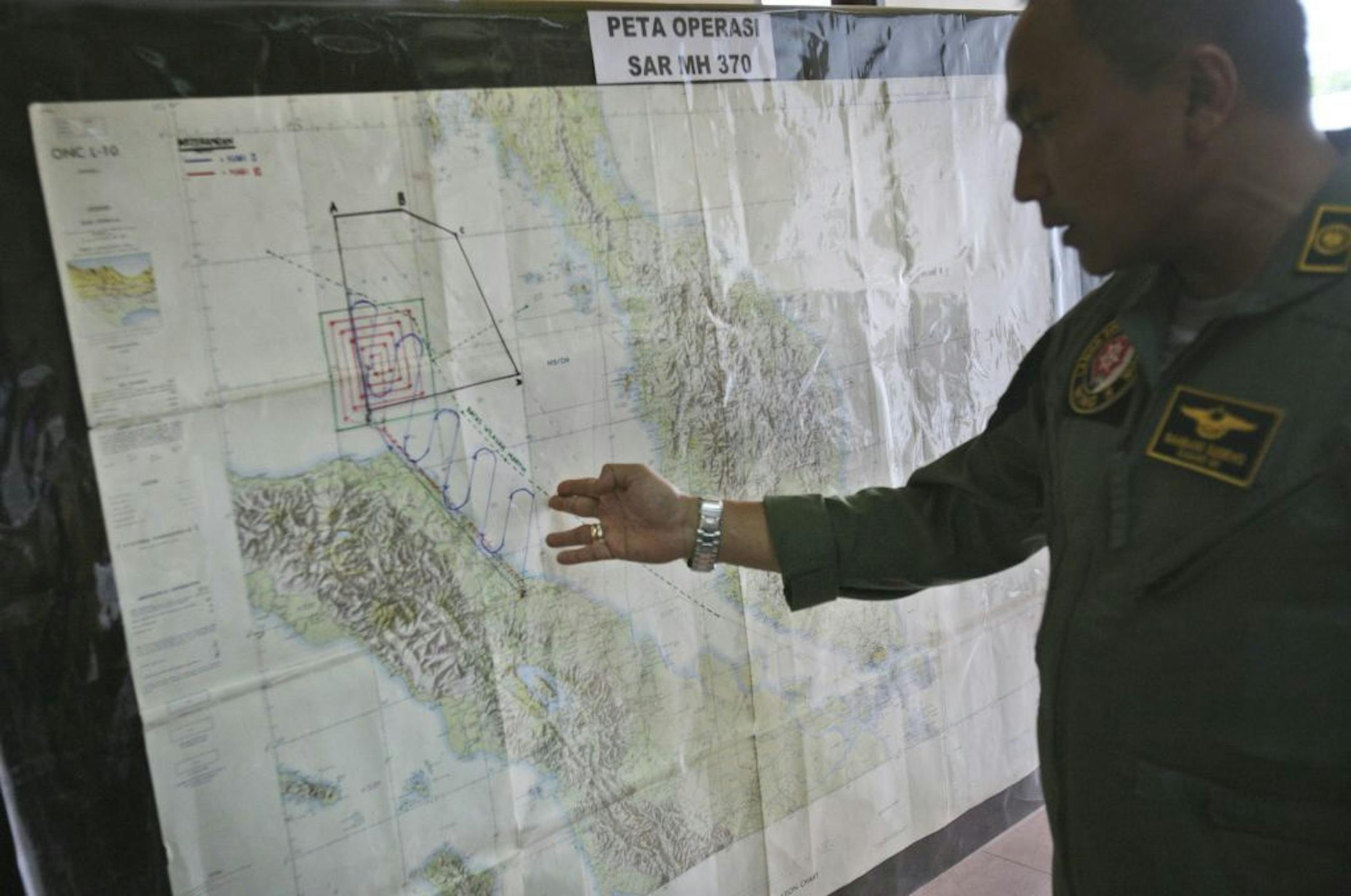 Lt. Col Bambang Sudewo, commander of the 5th Air Squadron "Black Mermaids" examines a map following a search operation for the missing Malaysia Airlines Boeing 777 on Friday, March 14, 2014.