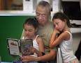 Rich Moy of Little Canada spent some time reading with granddaughters Melaina, 6, right, and Mila Moy.