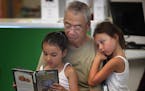 Rich Moy of Little Canada spent some time reading with granddaughters Melaina, 6, right, and Mila Moy.