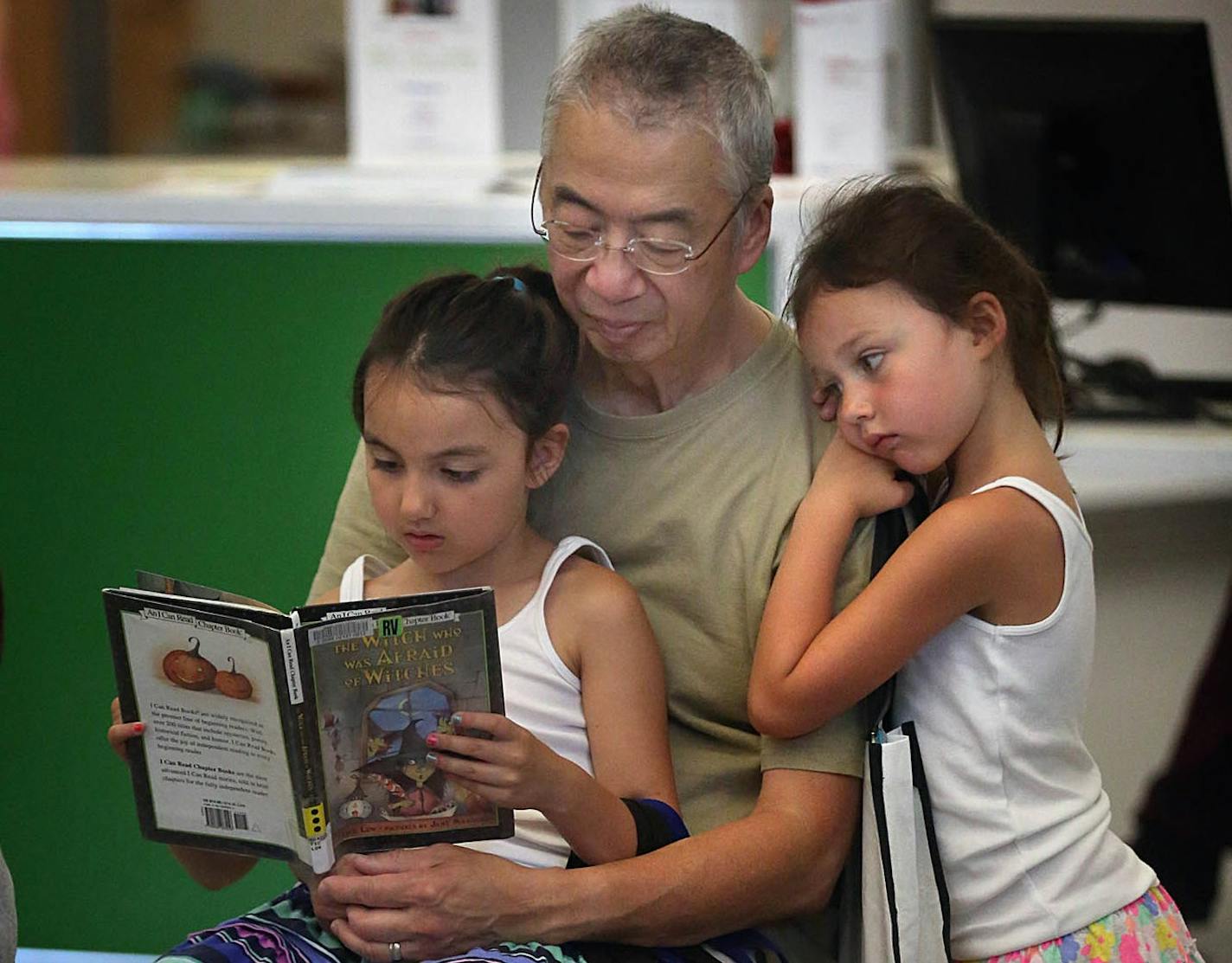 Rich Moy of Little Canada spent some time reading with granddaughters Melaina, 6, right, and Mila Moy.