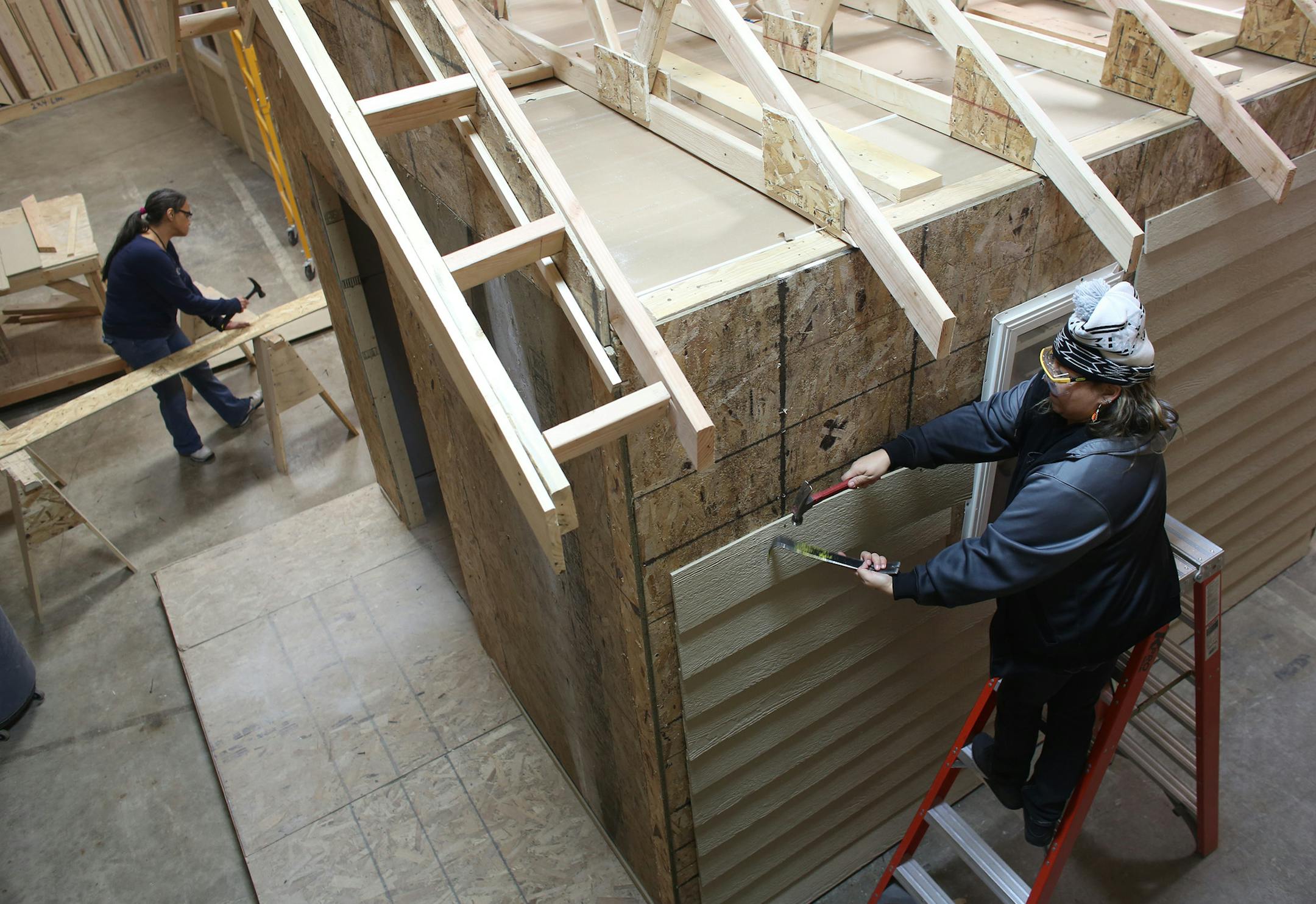 McKenzie Reynolds, 37, of St Paul, pried off the siding of one of the houses. ] (KYNDELL HARKNESS/STAR TRIBUNE) kyndell.harkness@startribune.com A 12 week construction trade program at Goodwill-Easter Seals in St Paul Min., Tuesday, January 6, 2014. The state just invested $500,000 in 7 grants to train women in manufacturing, truck driving and construction. Goal is to boost women's pay and narrow the gender gap.